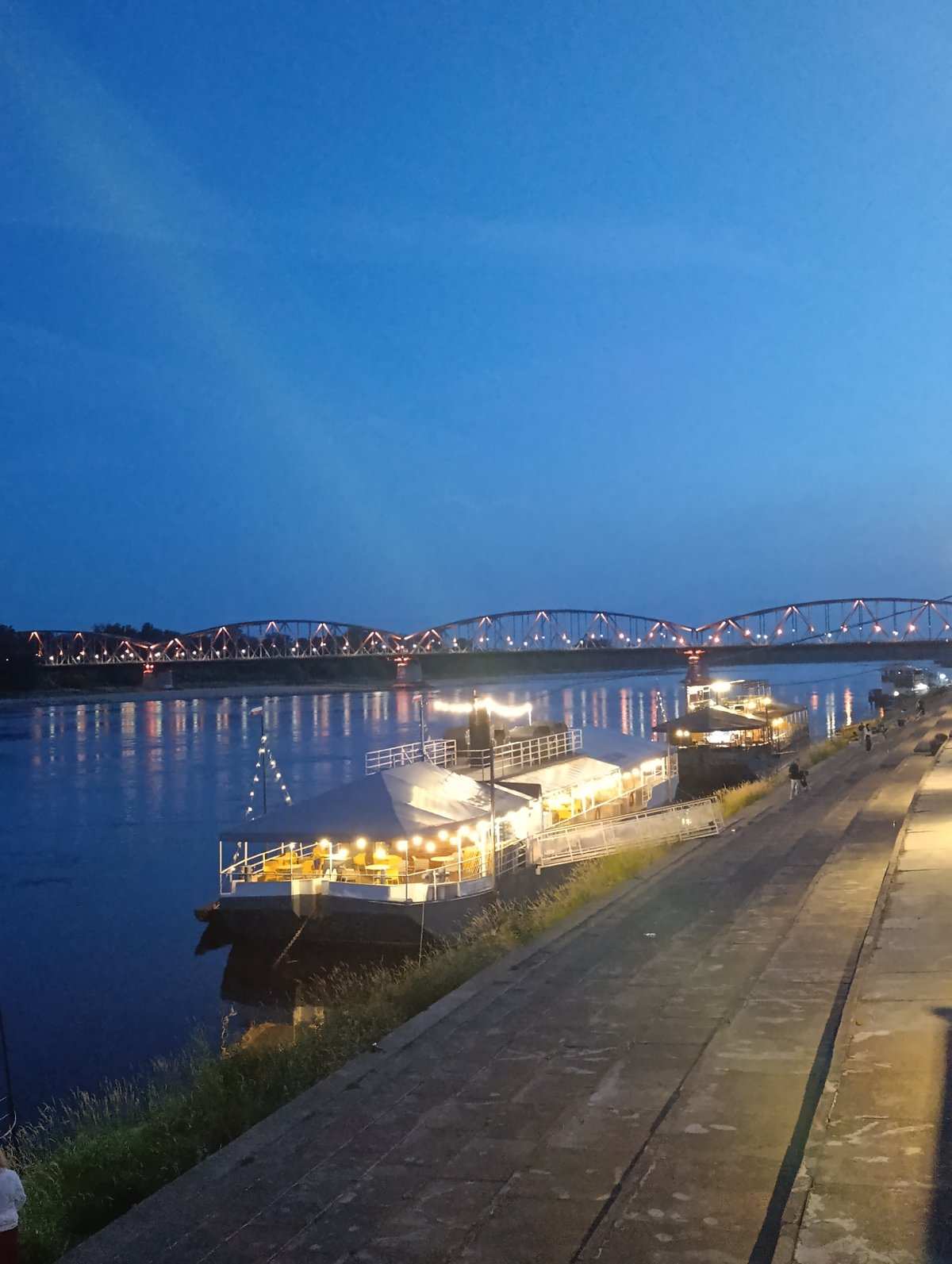 Toruń at dusk: riverfront lights and medieval walls