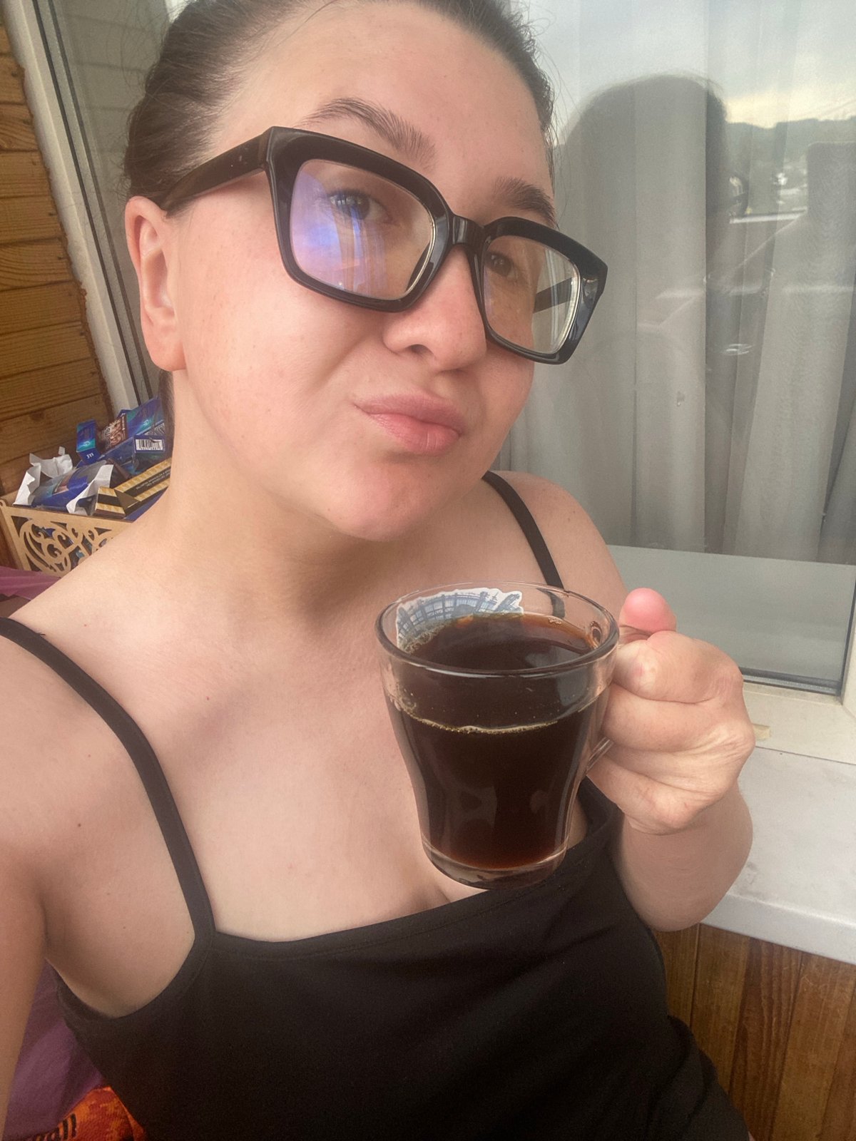 Woman enjoys morning coffee amid cloudy skies in Chaikovsky