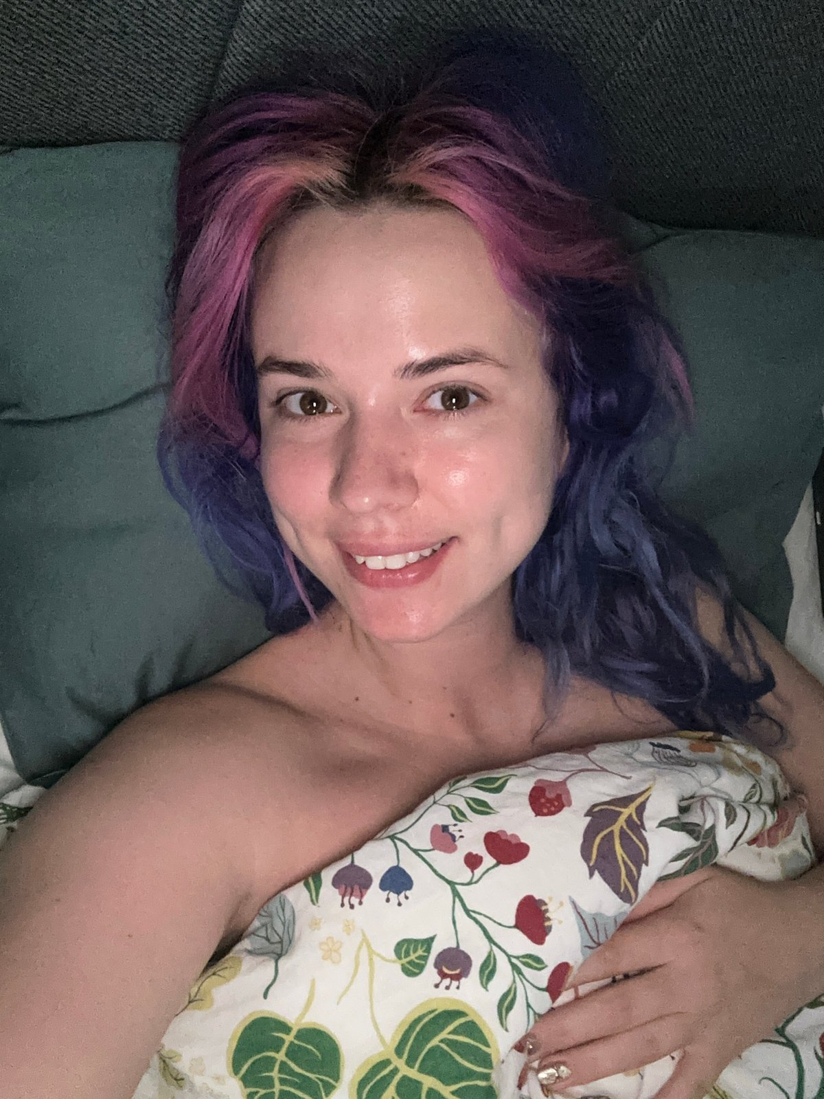 Woman with colorful hair relaxes on couch in Zagreb