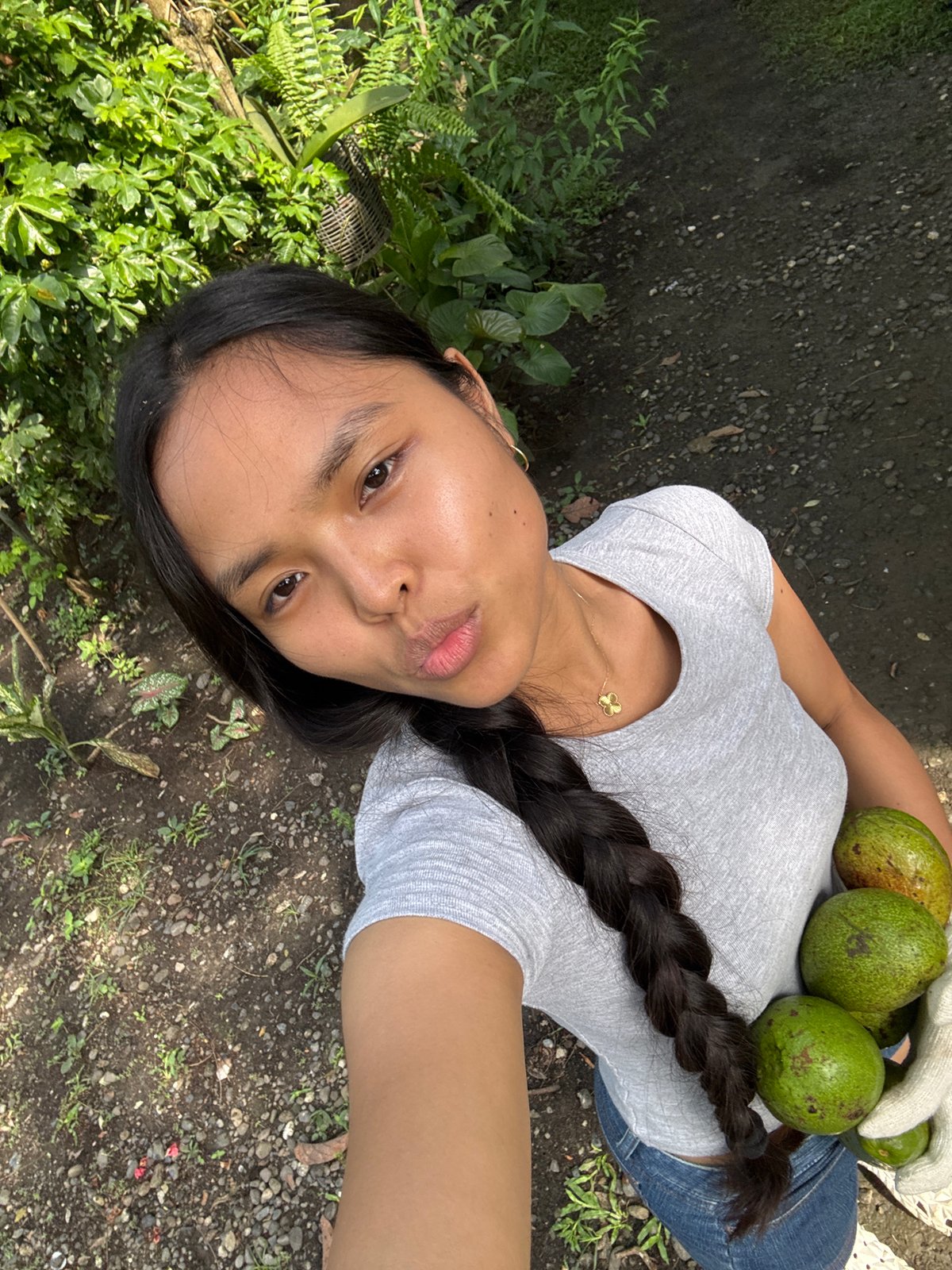 Woman holds avocados outdoors in Carmen, Philippines