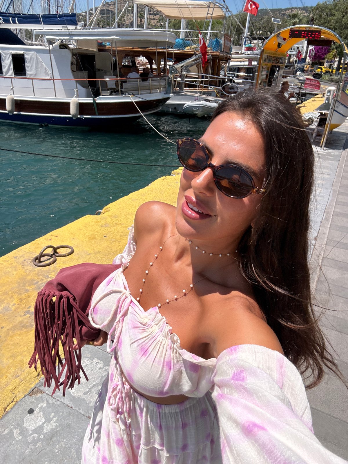 Woman takes selfies at Bodrum harbor pier