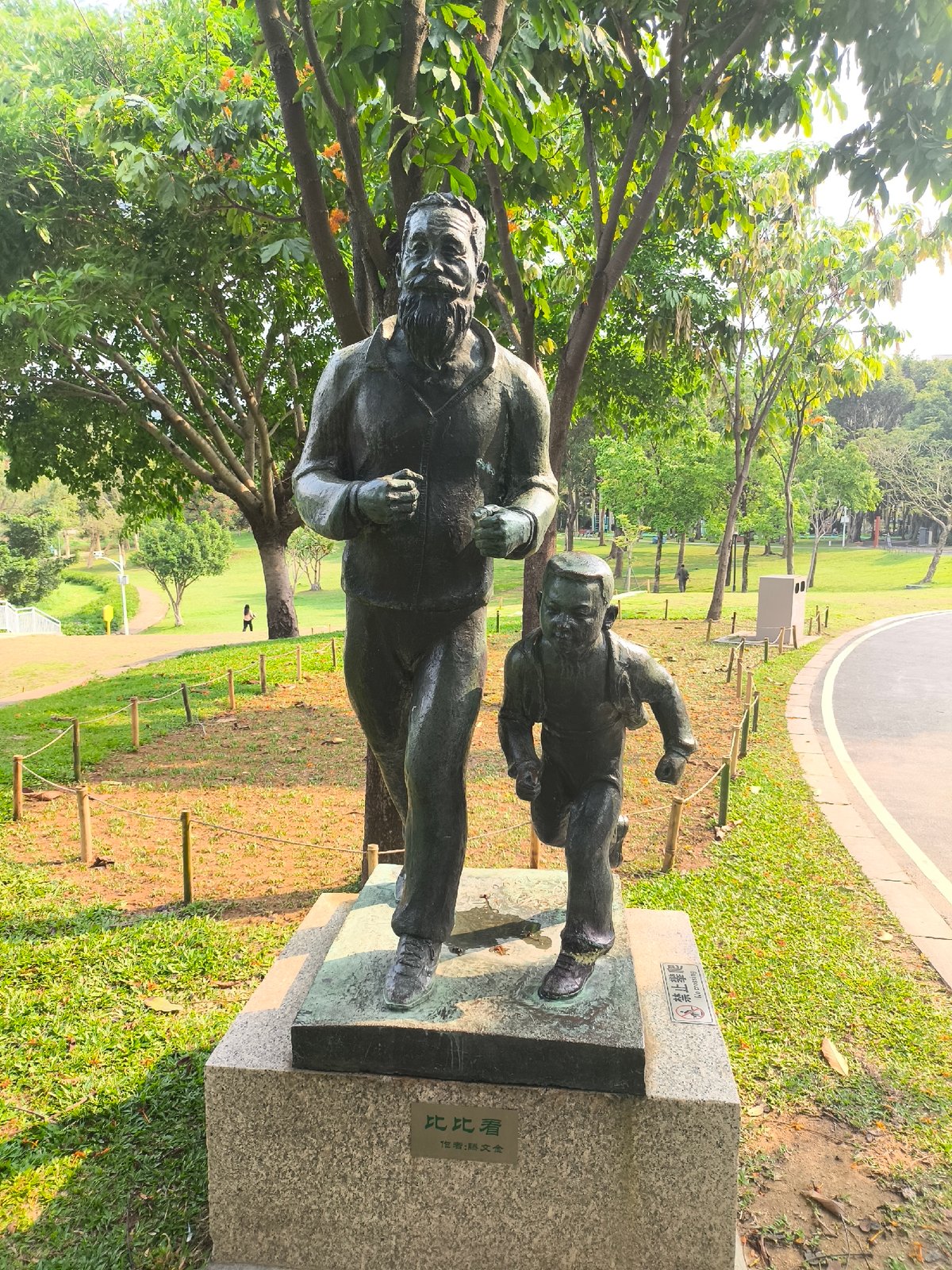 Bronze statue of man and boy running observed in Futian