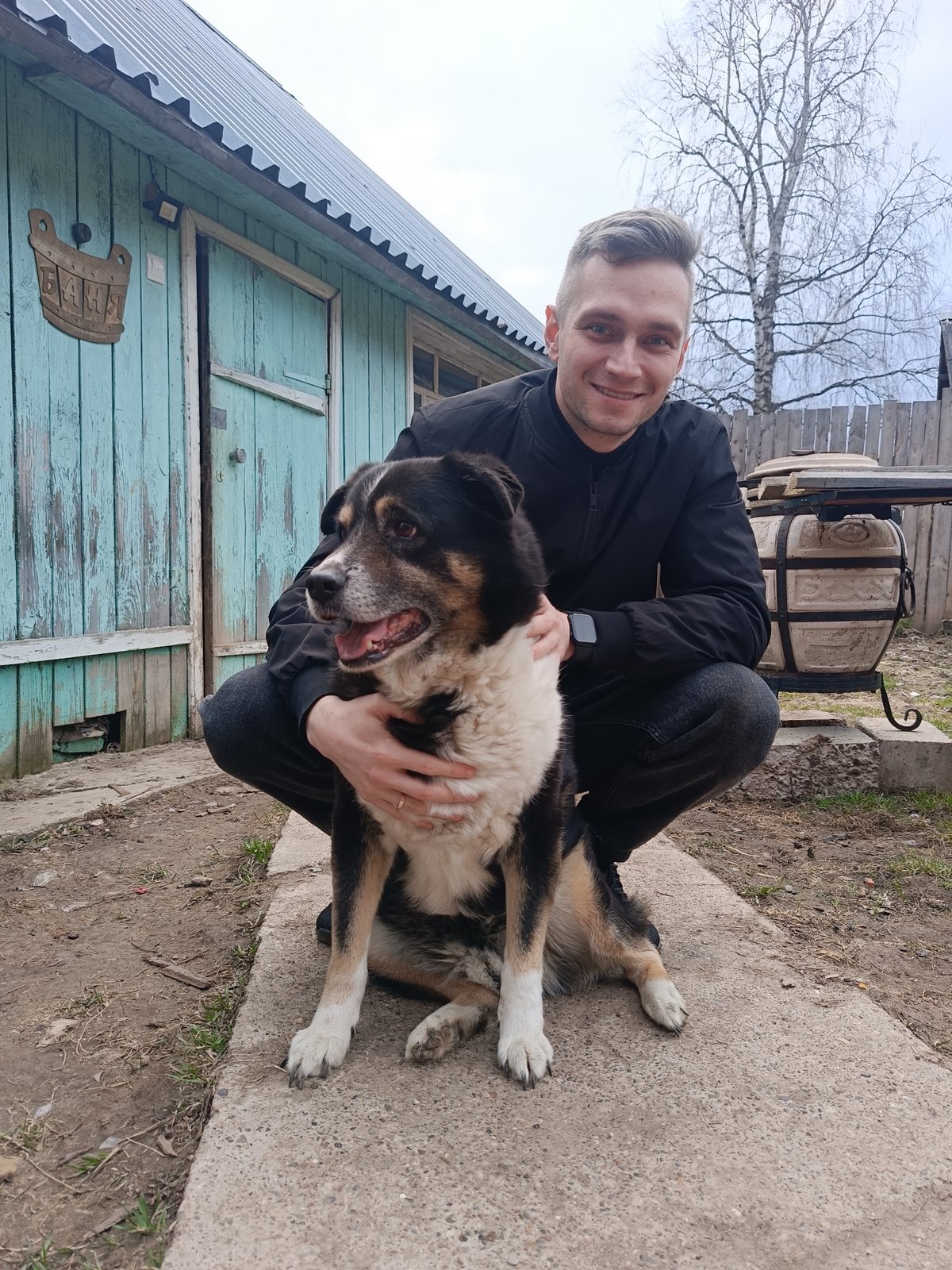 Man photographs with dog in rural Russian village