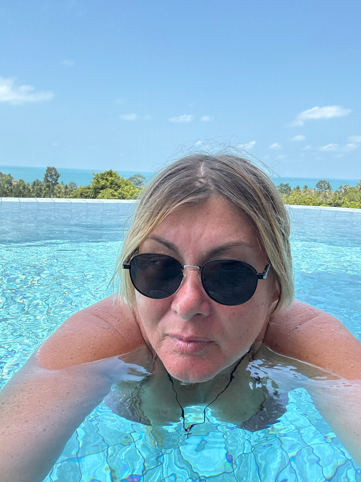 Tourist documents leisurely morning at Thai resort pool