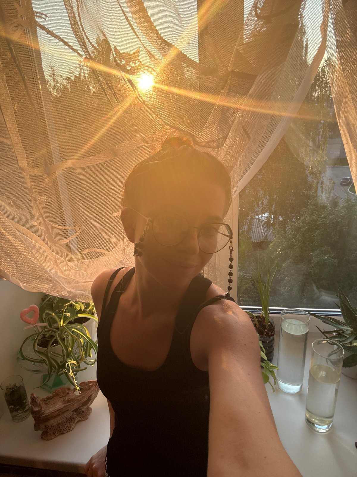 Golden hour selfie session by a curtained window with a white cat