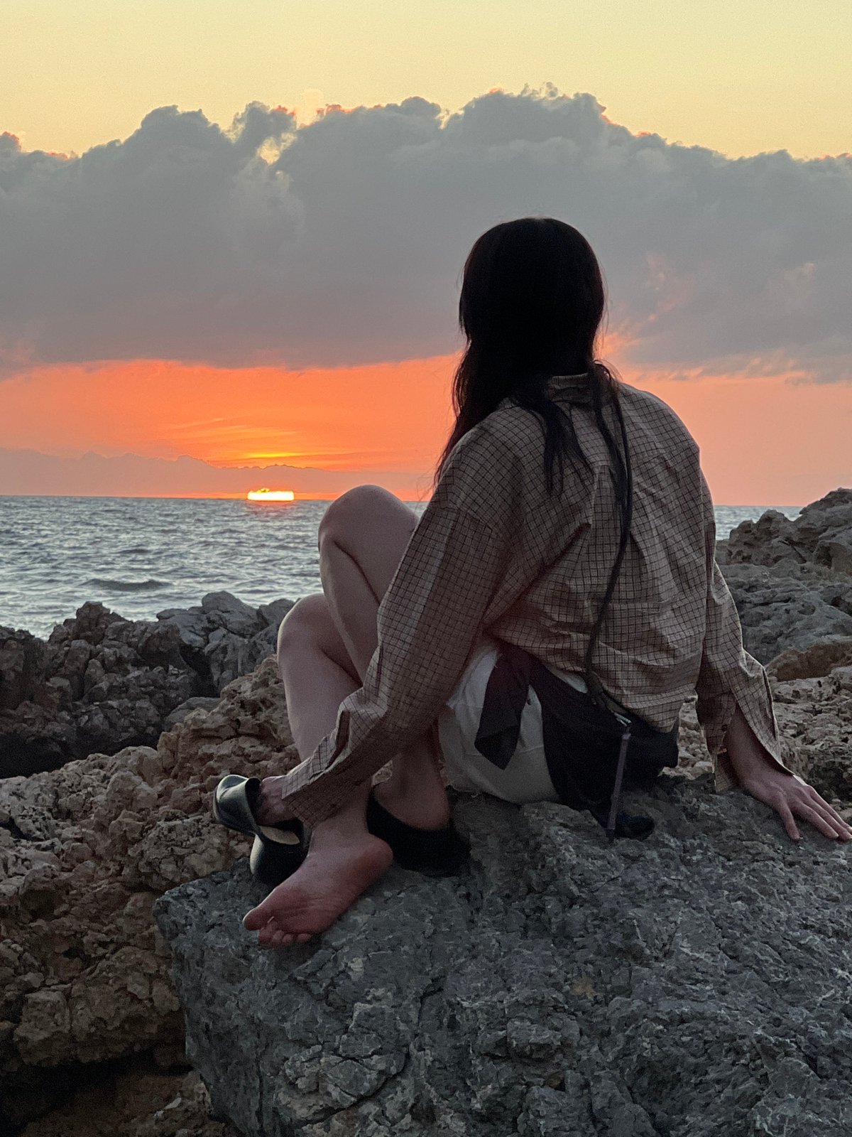 Sunset watchers gather on Palermo's rocky coastline Mediterranean evening