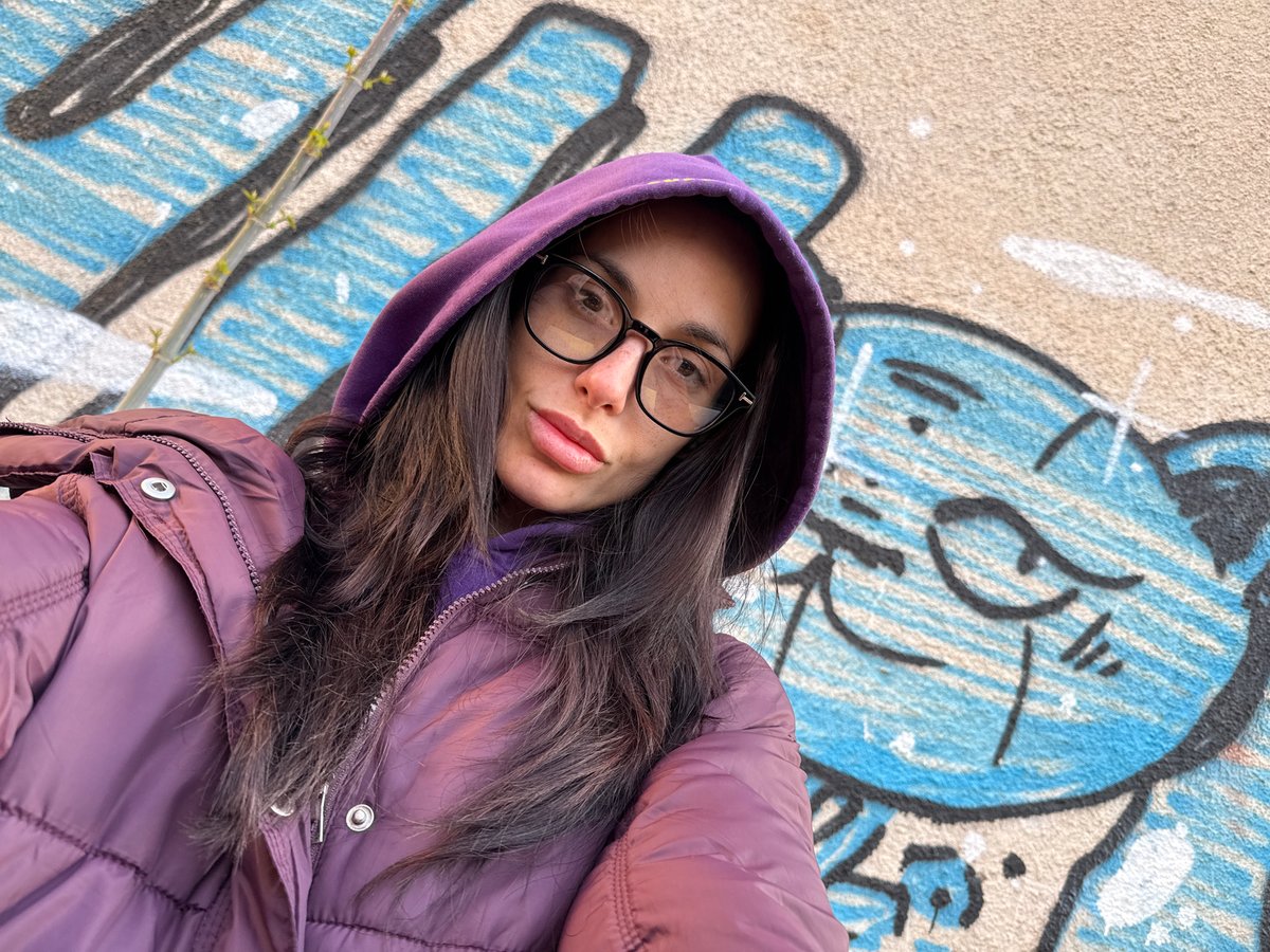 Woman rests on colorful graffiti surface in Pleven
