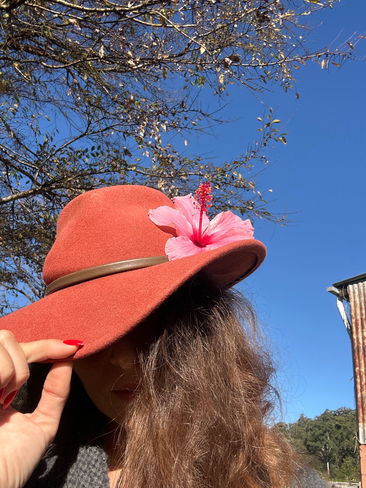Felt hat with hibiscus flower, styled and shot outdoors in Thora
