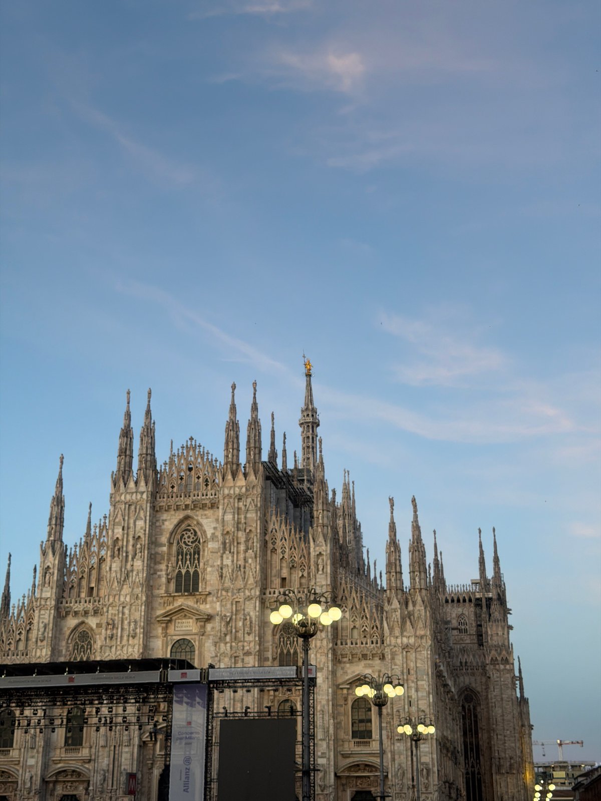 Pedestrians gather around Milan's Duomo during overcast afternoon
