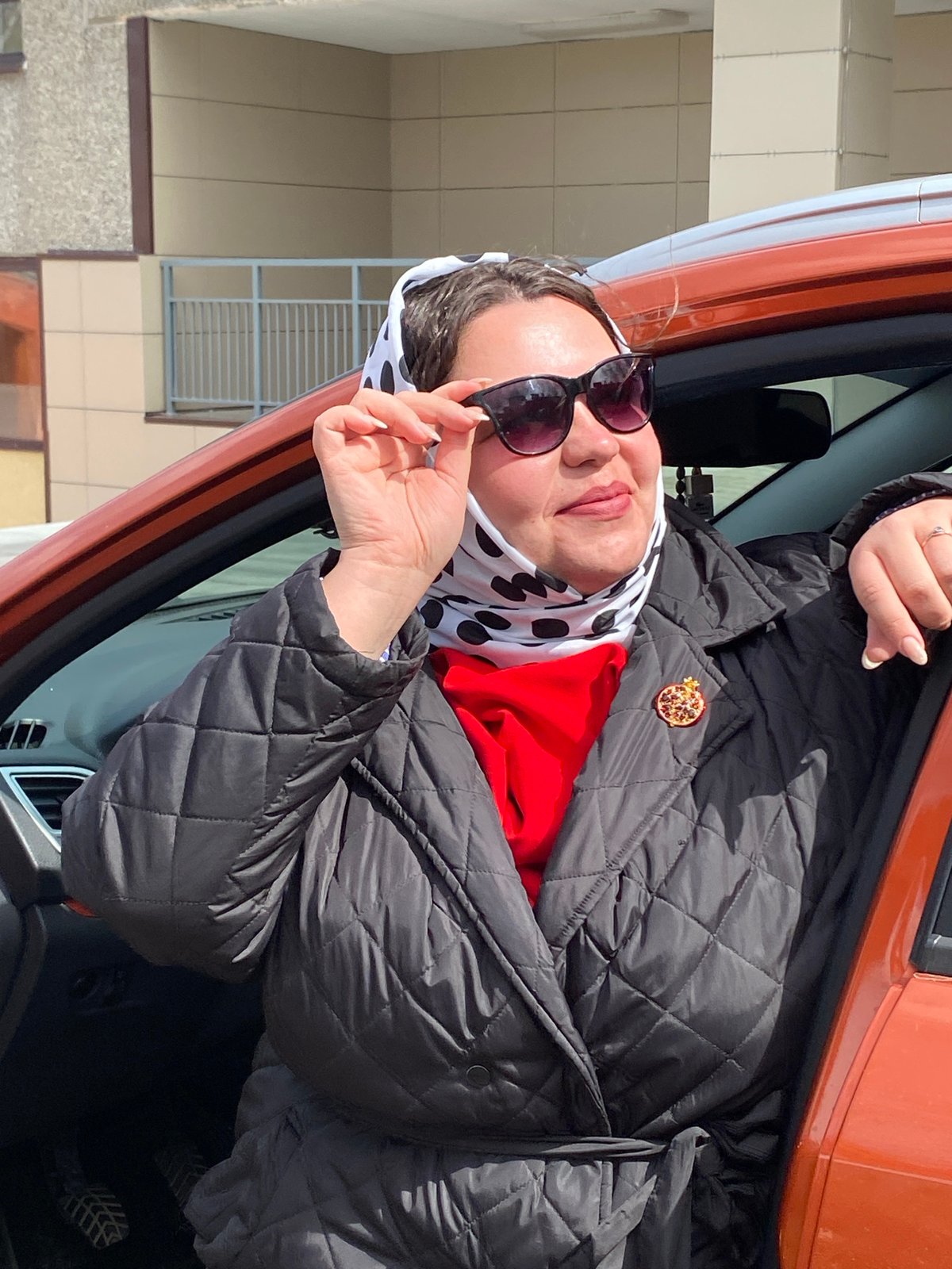 Women photographed with orange car in Марковский, Russia