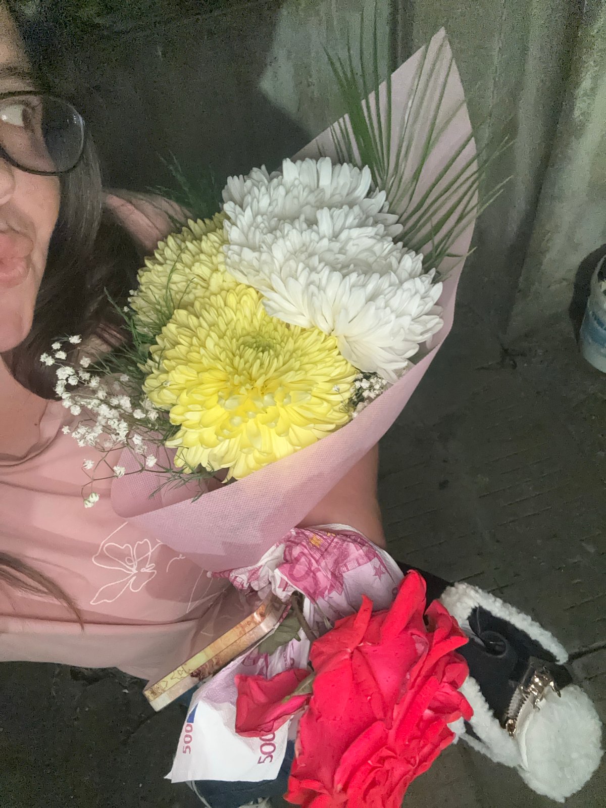 Person holds flower bouquets and money in Bulgarian village