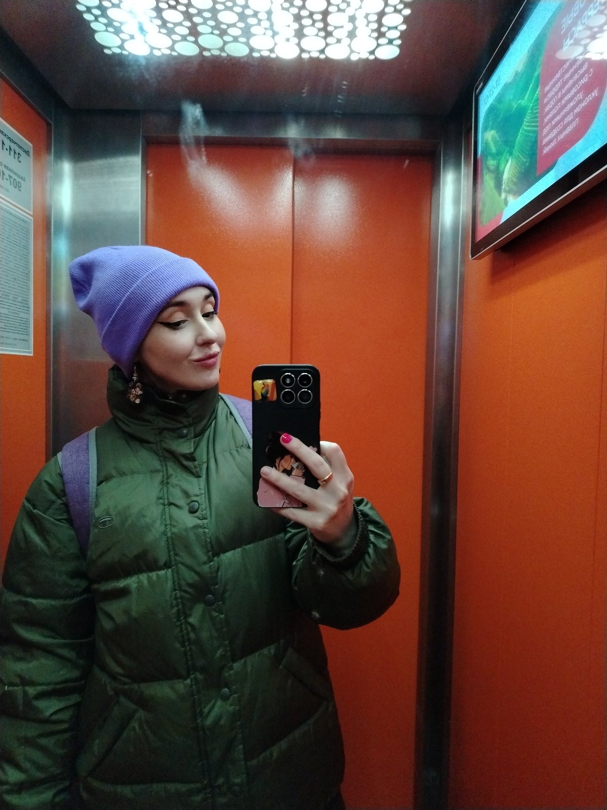 Woman takes elevator selfies in Izhevsk wearing purple beanie