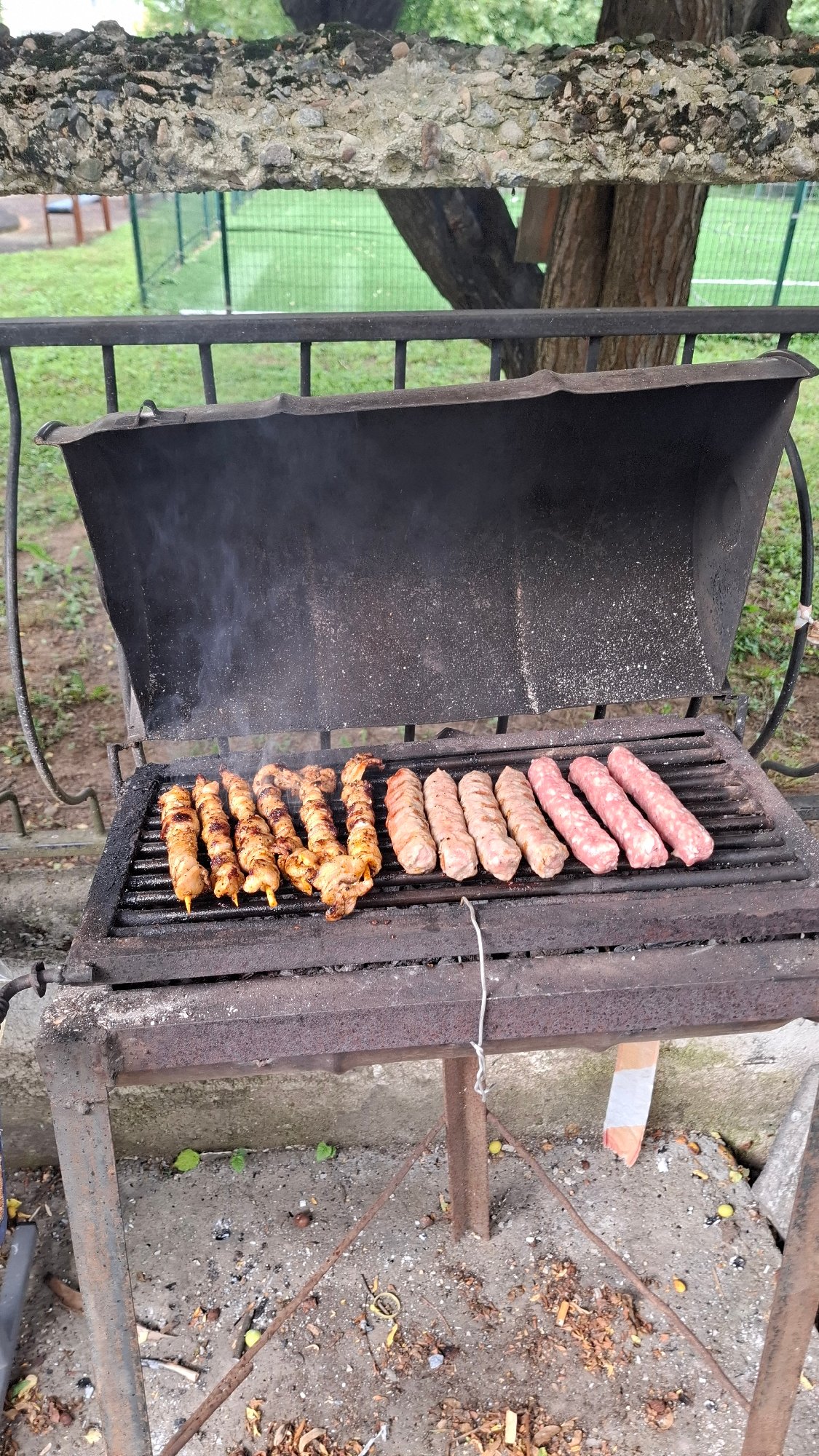 Meat and sausages grilling over an active barbecue