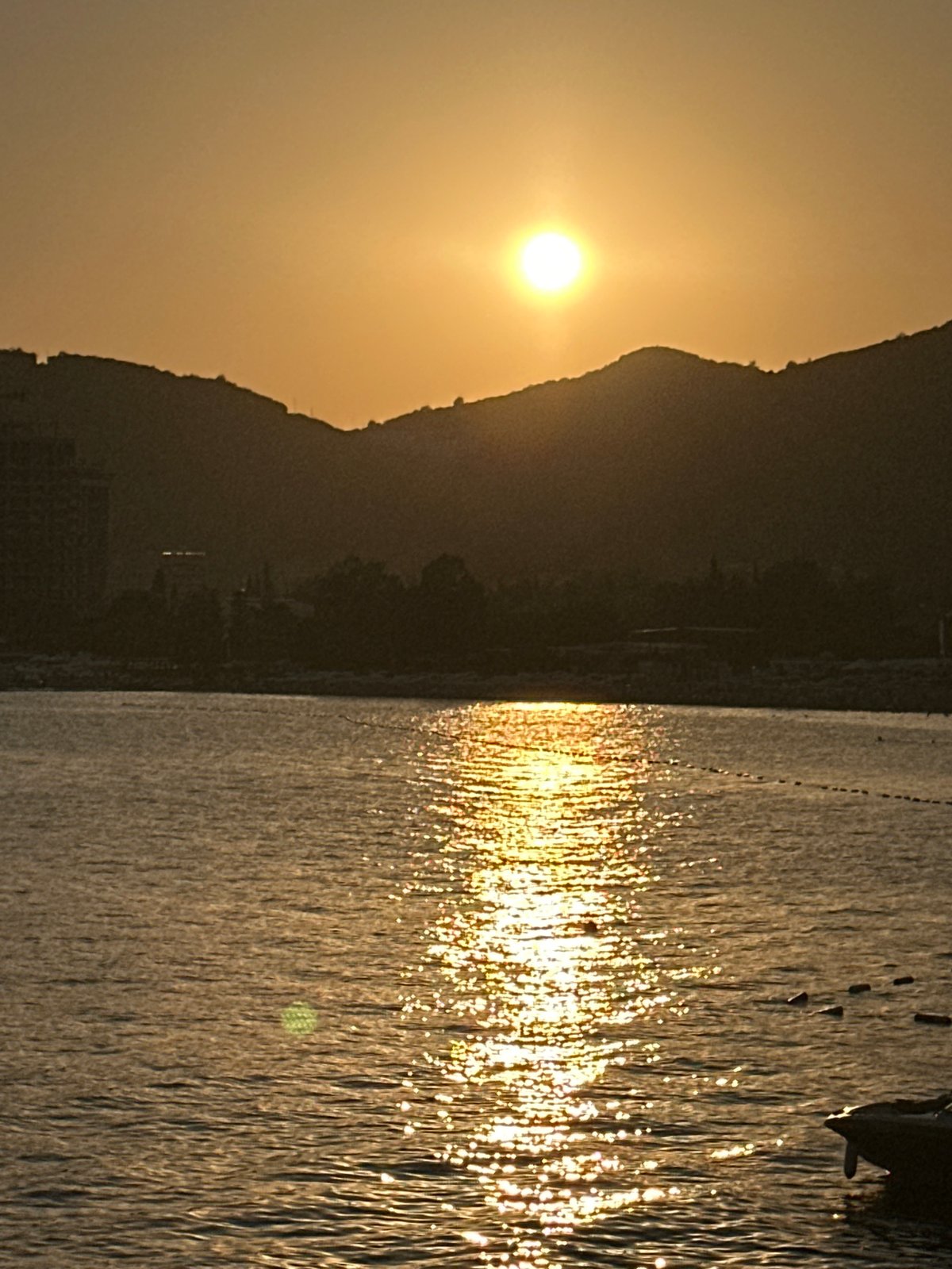 Sunset over Budva's calm Adriatic waters with boats nearby