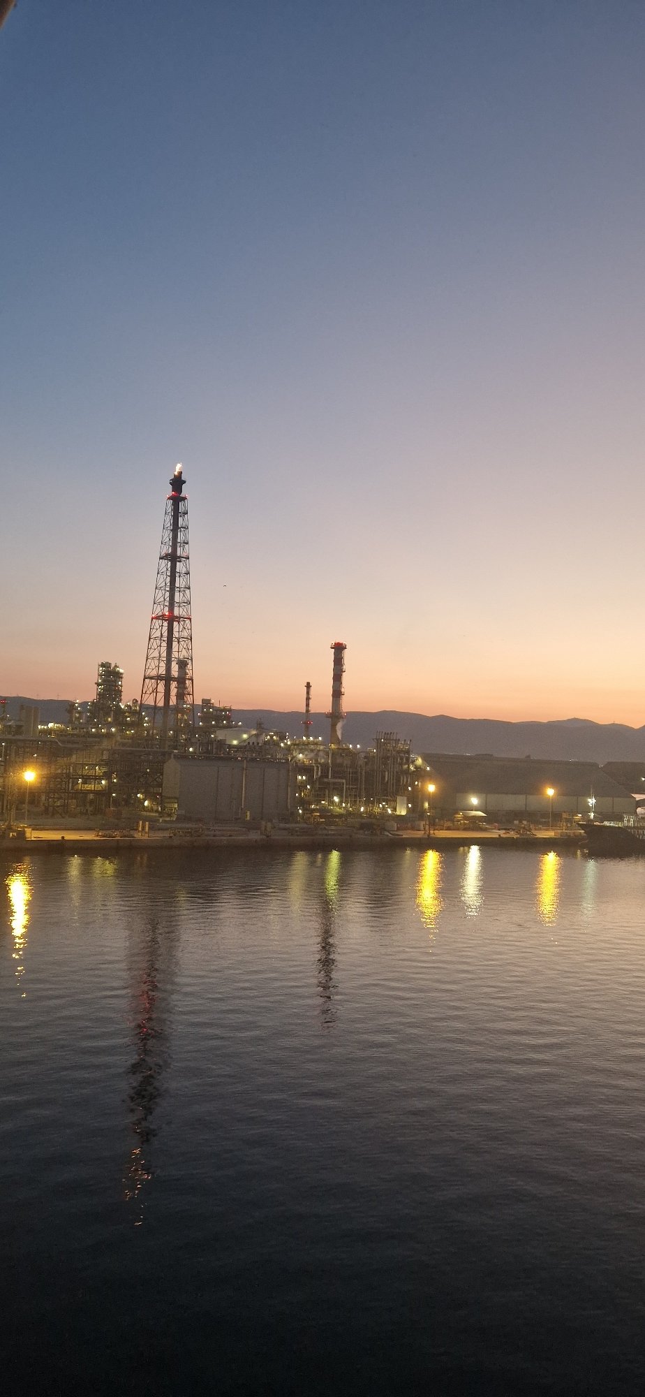 Industrial waterfront at dusk, sky painted in gradient hues