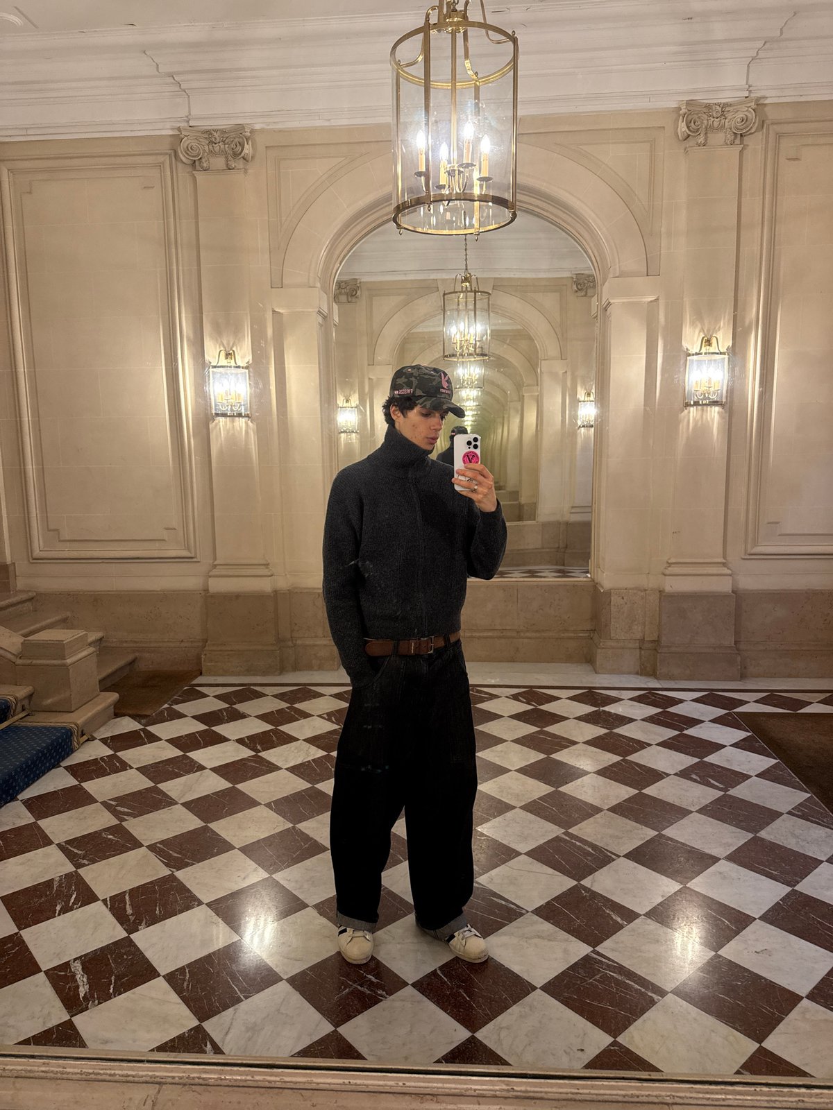 Man takes mirror selfie in upscale Parisian interior
