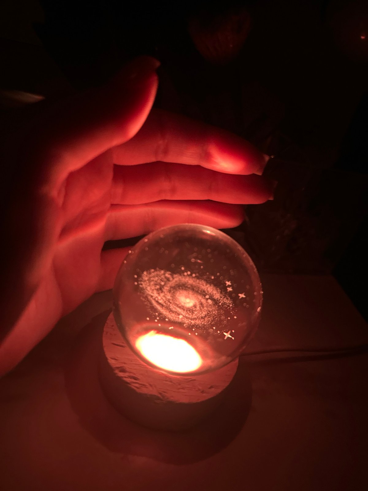 Person handles perfume bottles and glowing objects indoors