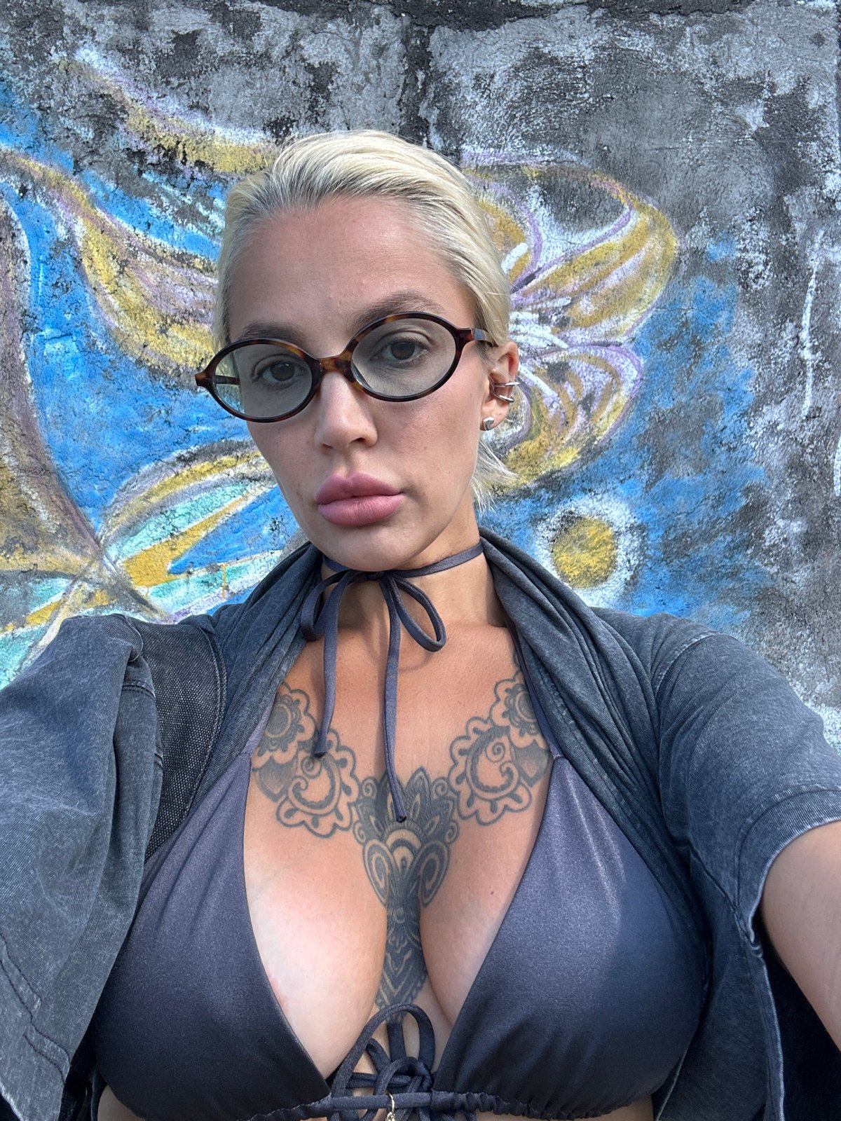 Woman photographs herself near street art in Kuta Selatan