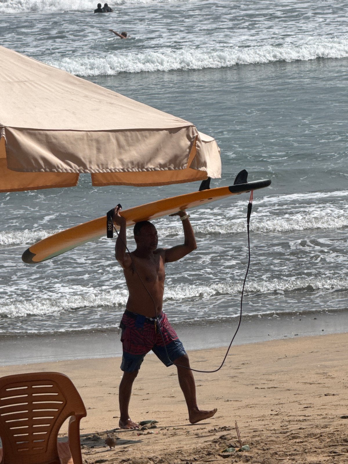 Surfers and beachgoers on a busy Kuta Beach morning