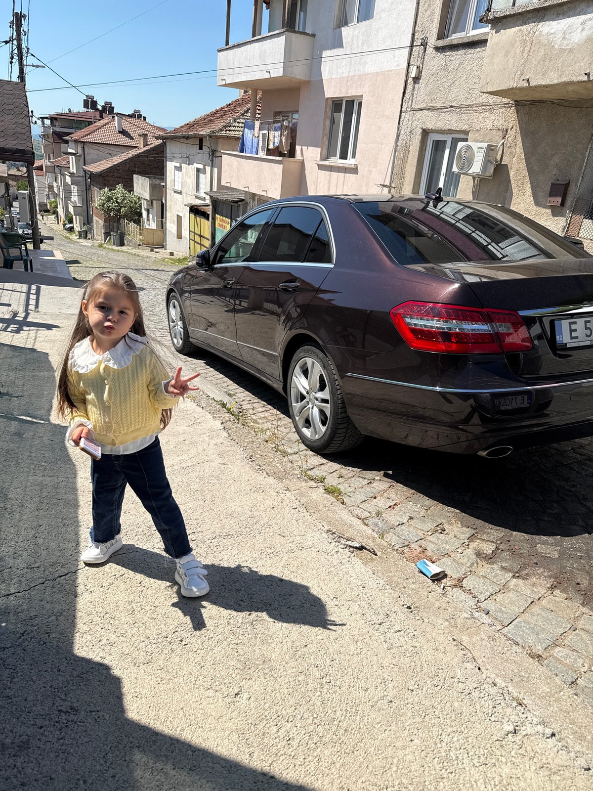 Girl in yellow cardigan observed on Sandanski sidewalk