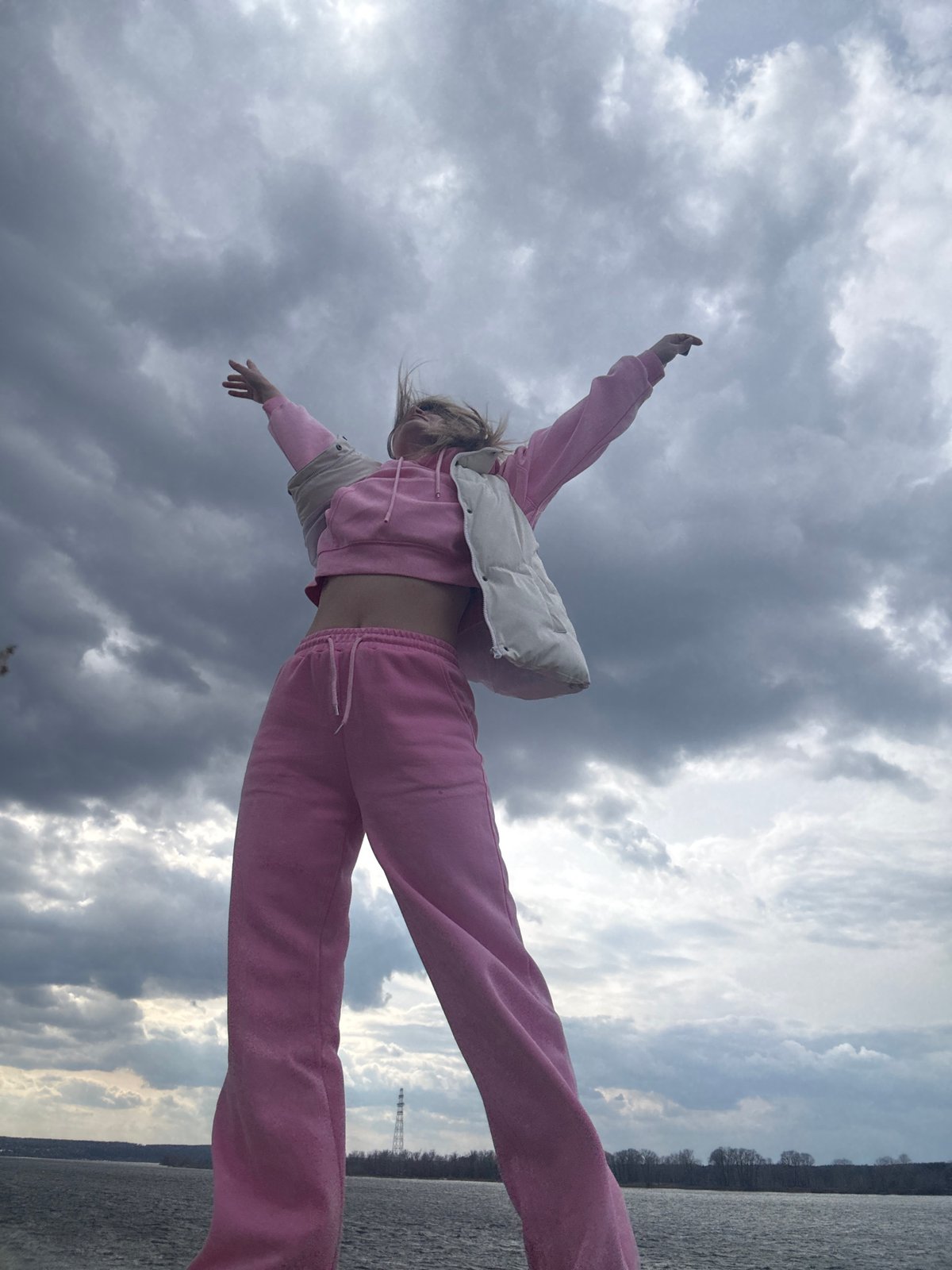 Woman poses for photos along Chaikovsky waterfront during overcast morning