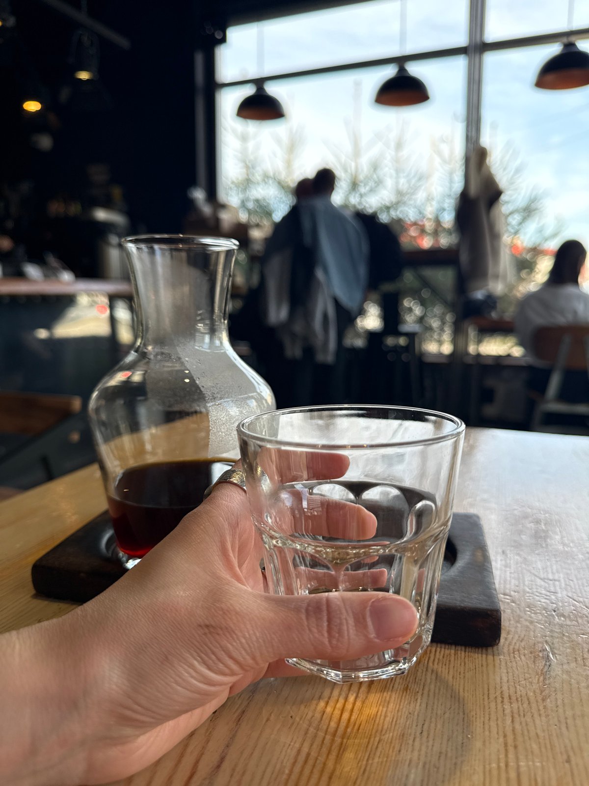 Person pours dark liquid from carafe into glass in Kazan