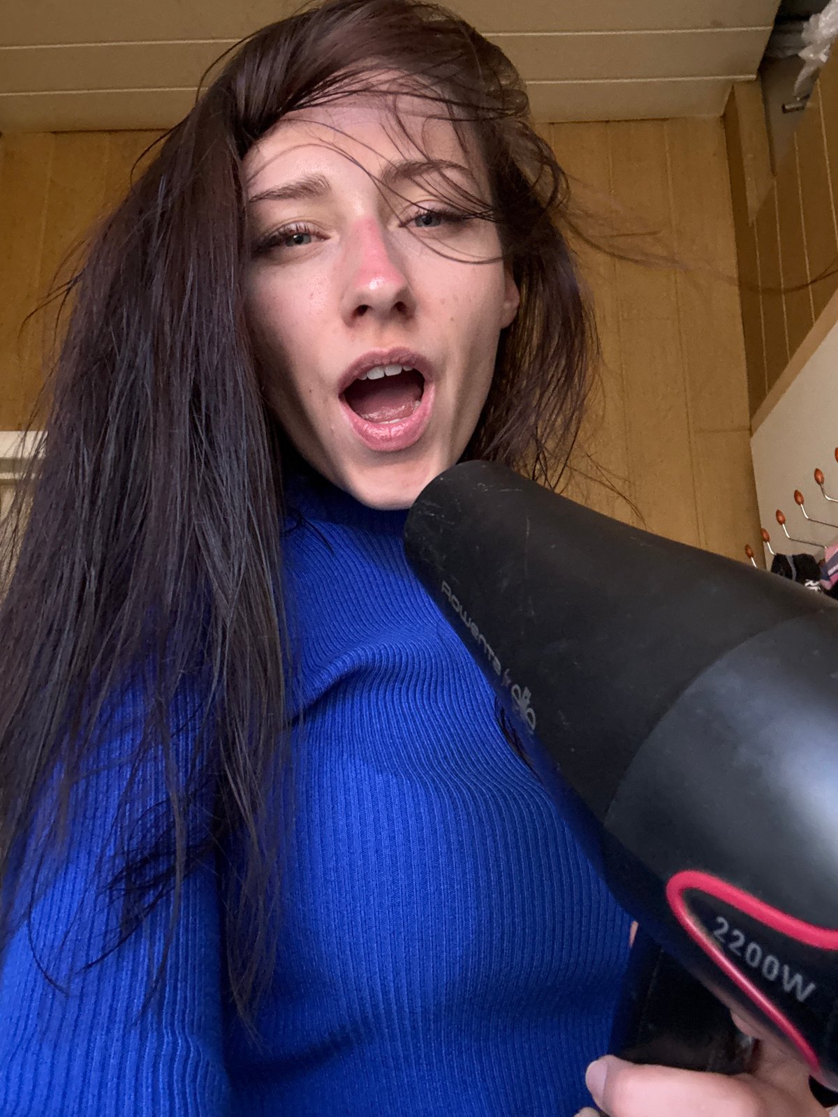 Woman dries hair indoors in Saint Petersburg apartment