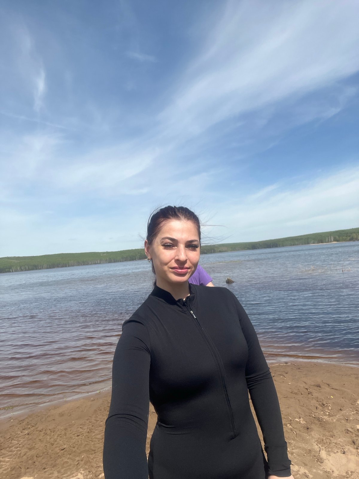 Woman and dog enjoy morning lakeside visit in Chaikovsky