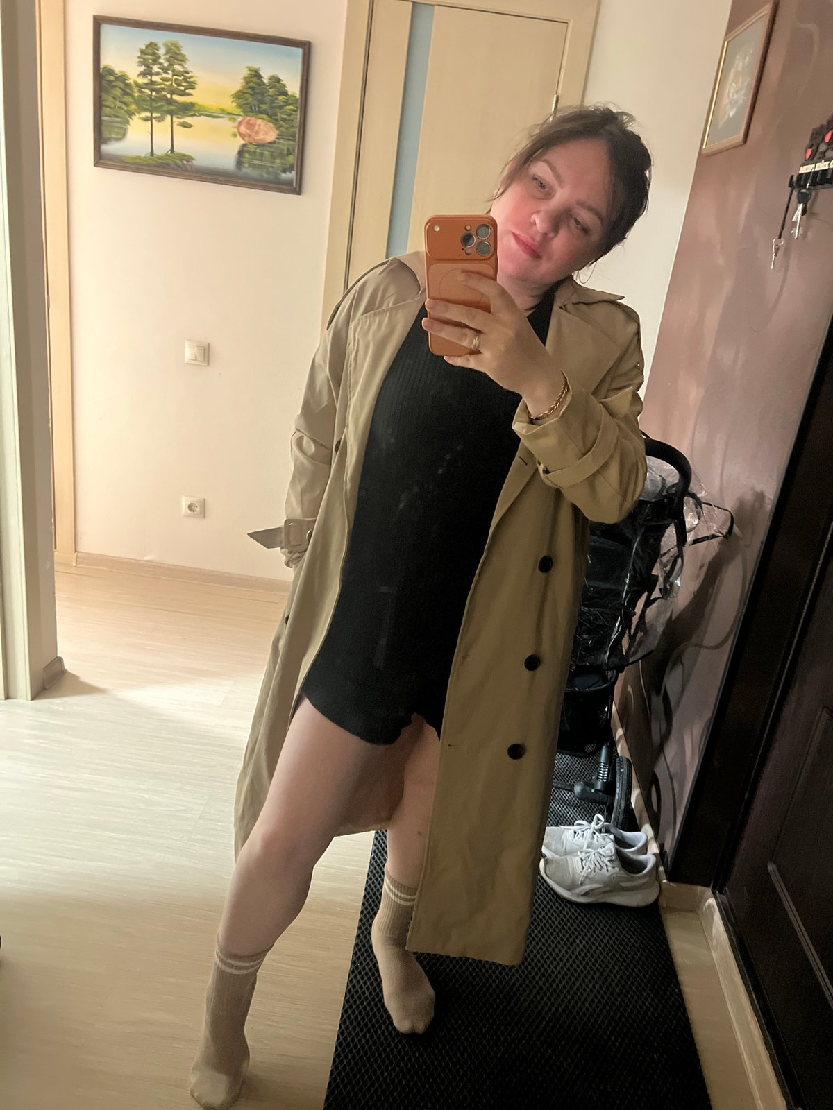 Woman takes selfie with orange phone in Perm apartment
