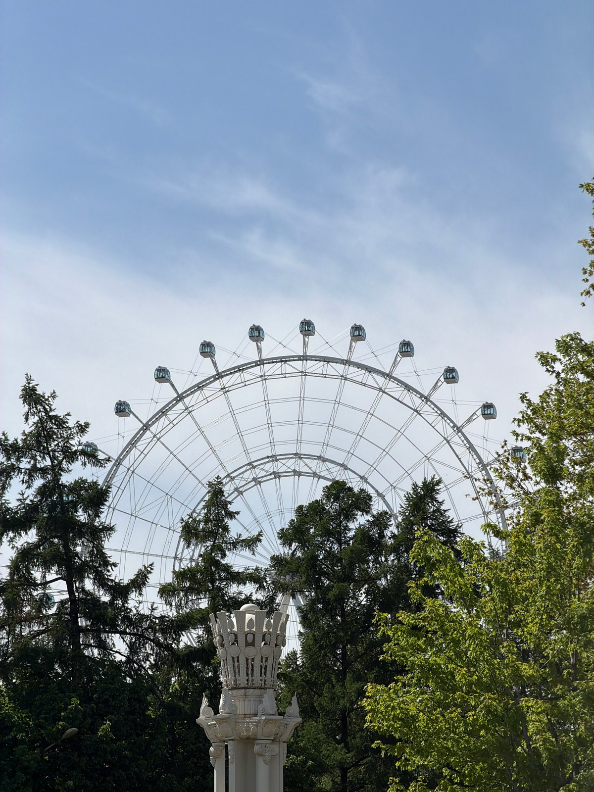 White Ferris wheel spotted against blue sky in Moscow