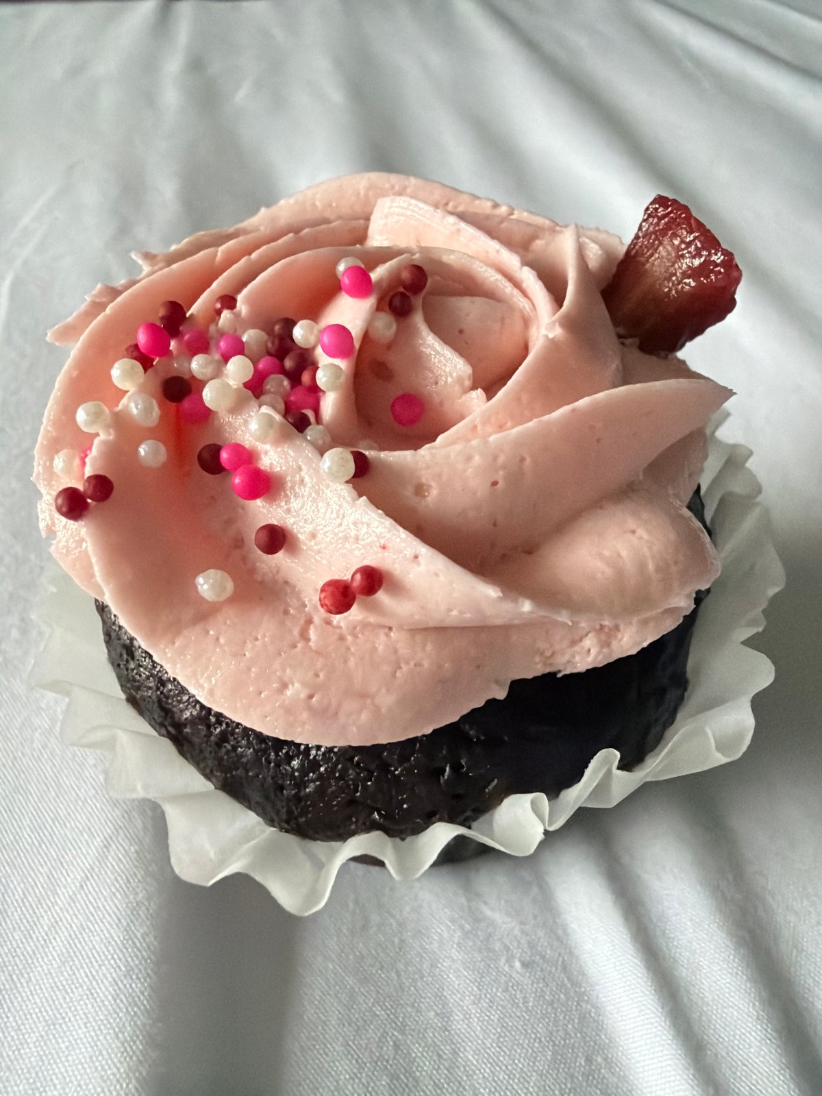 Chocolate cupcake with pink frosting photographed in Toronto