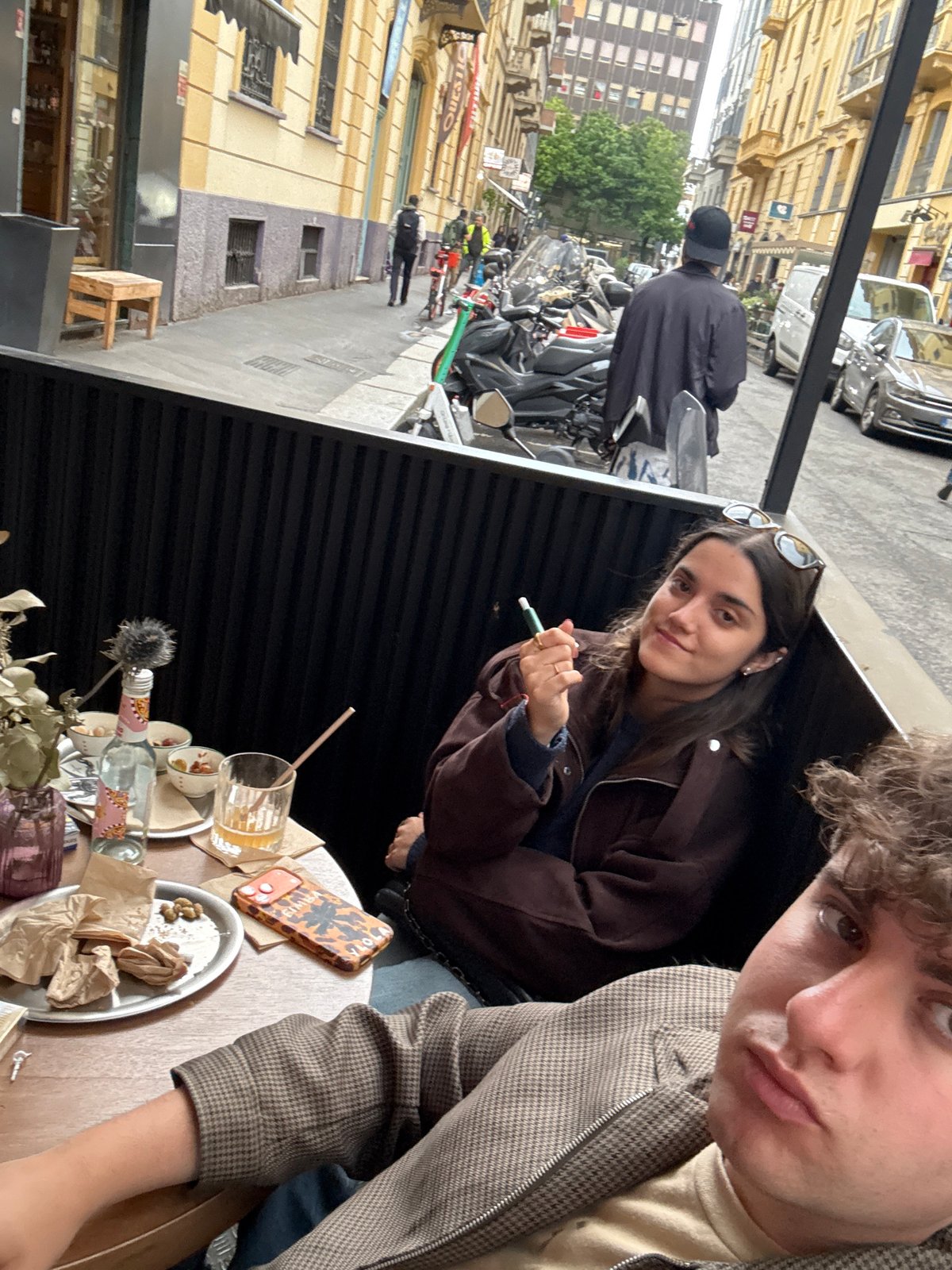 Two young people photographed at outdoor table in Milan