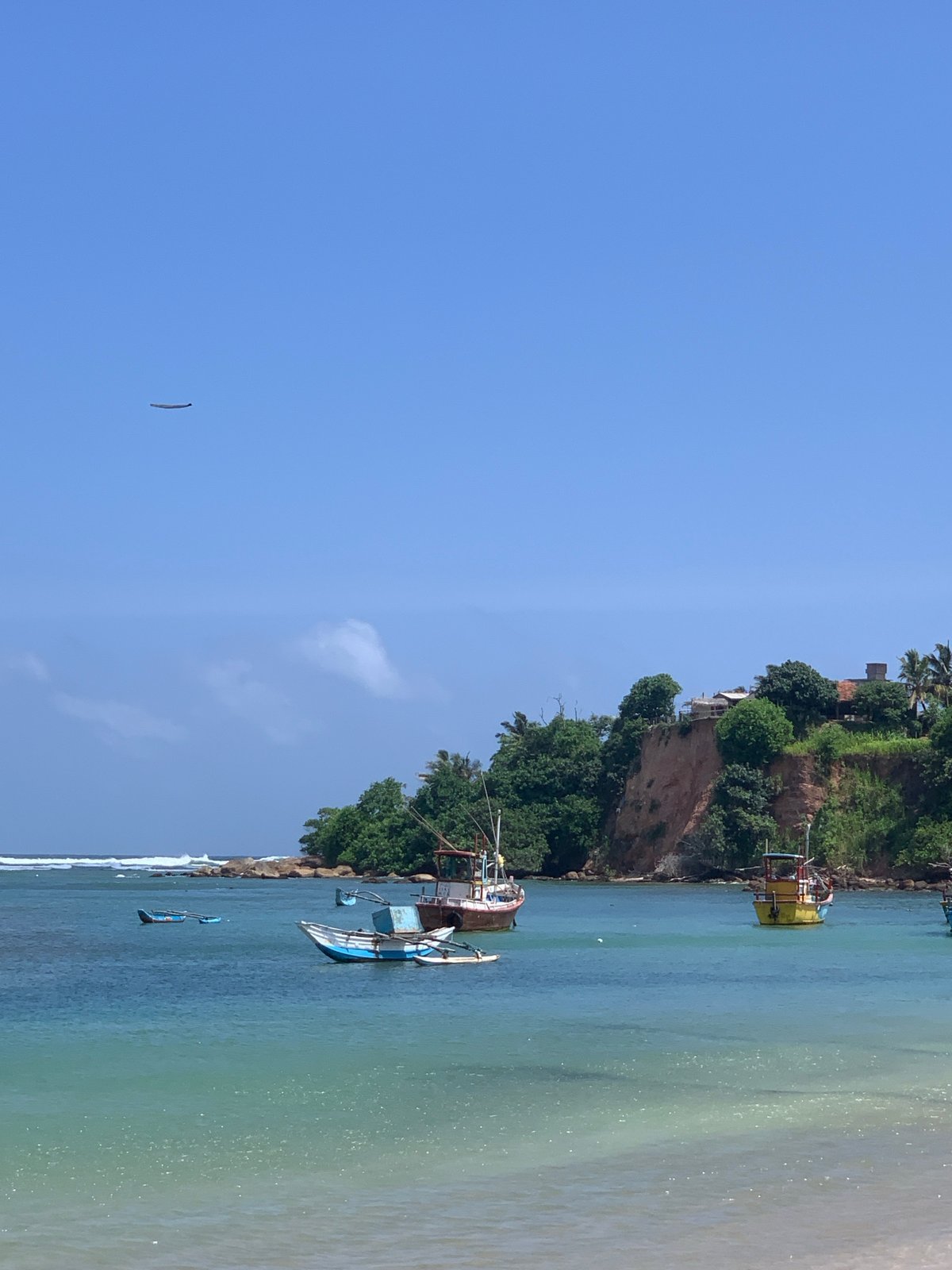 Colorful fishing boats dot the shore and bay at Weligama