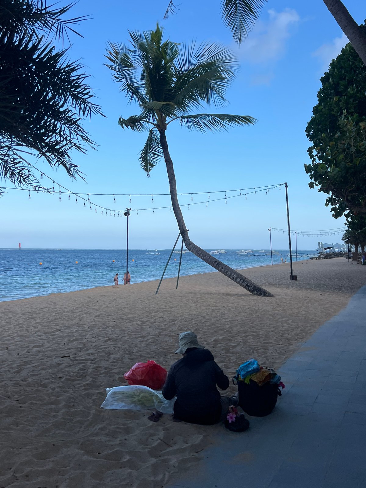 Morning buzz along Denpasar's beachfront — water sports, food carts, and promenade life