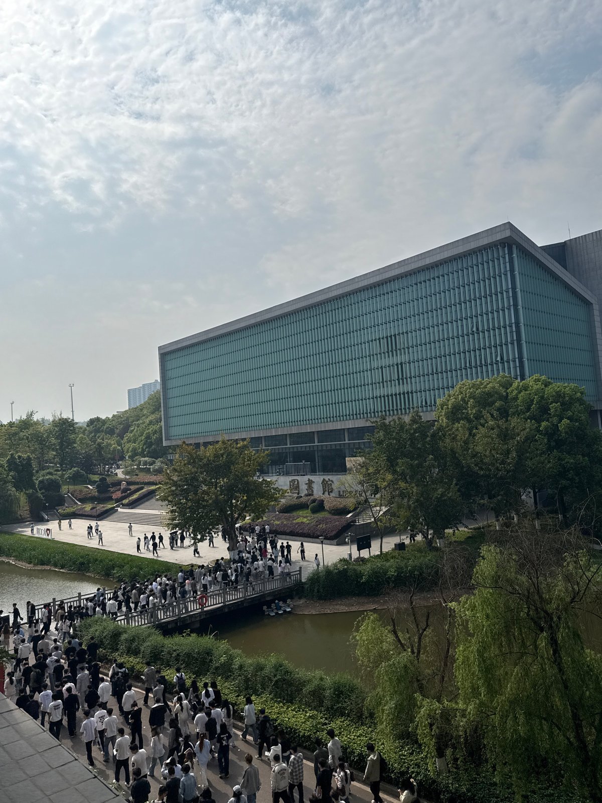 Large crowd walks past modern library in Jiangjin