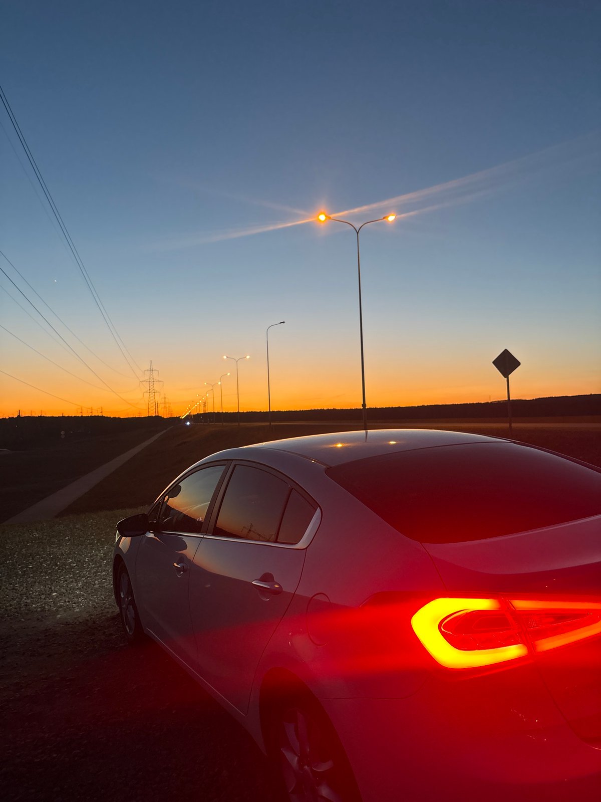 Woman photographed by highway at dusk in Chaikovsky, Russia