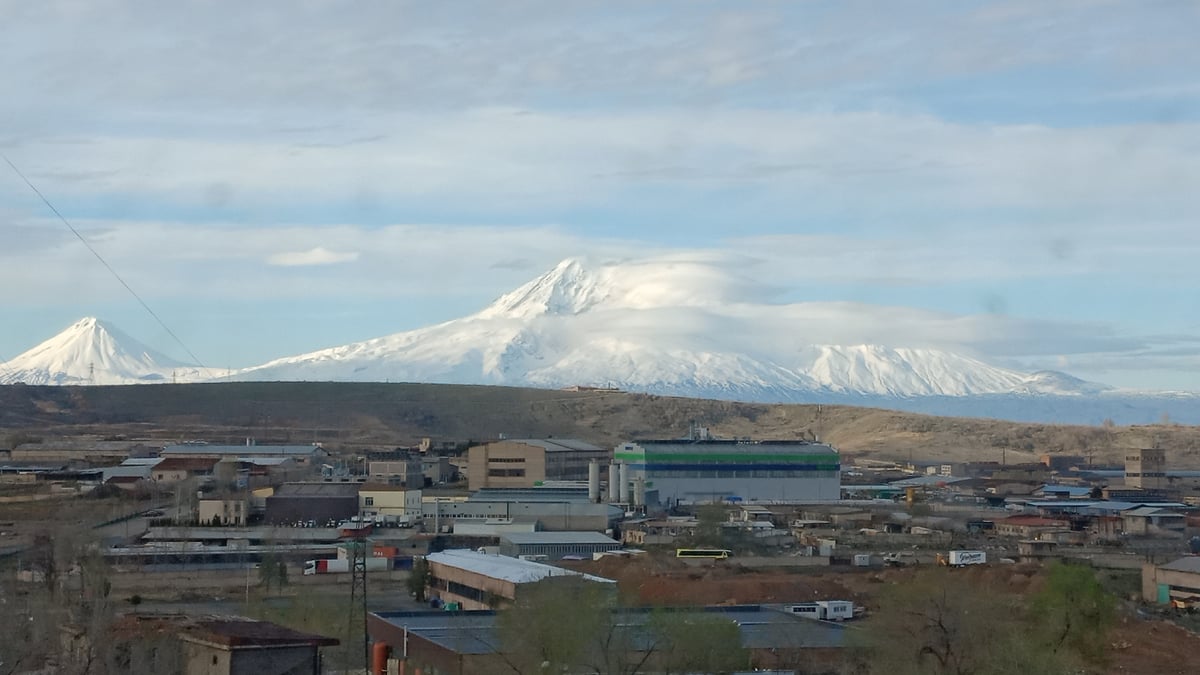 Snow-capped mountains backdrop viewed from Yerevan under cloudy skies