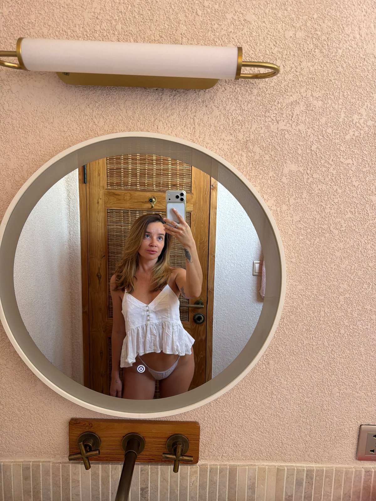 Woman takes mirror selfies in bathroom in Mengwi, Indonesia