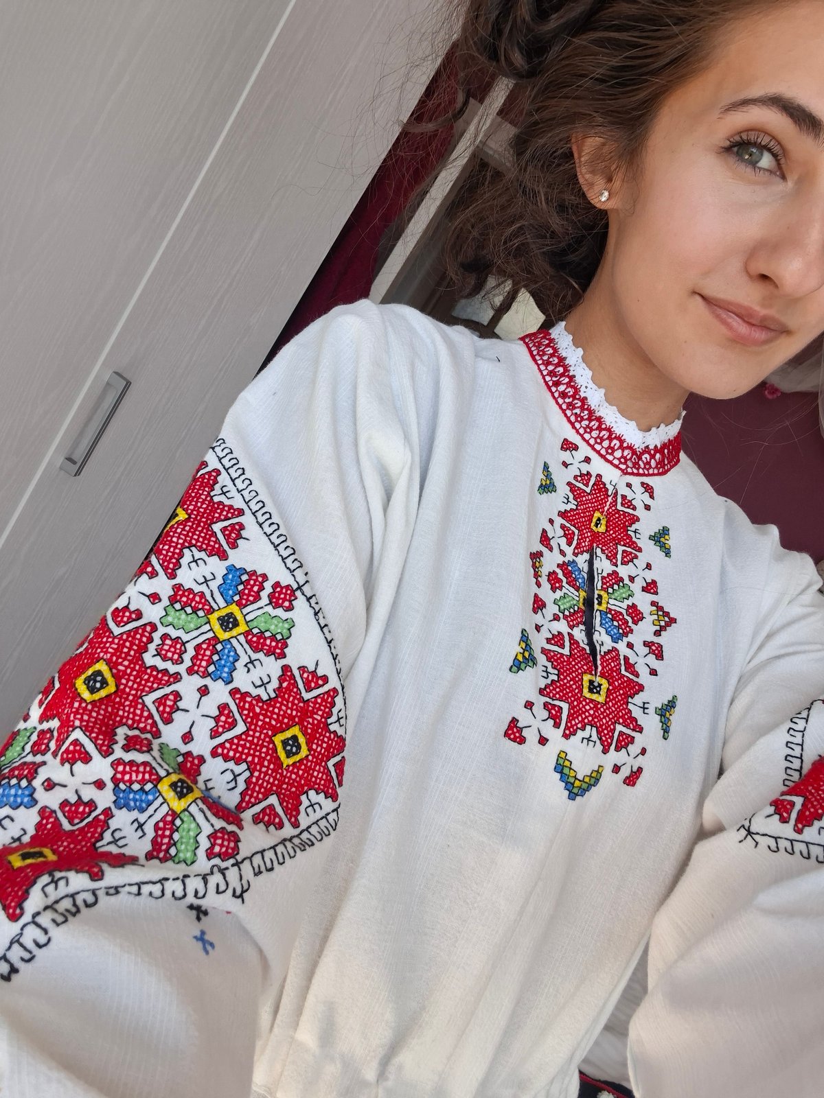 Traditional embroidered outfit and ornate headpiece on display