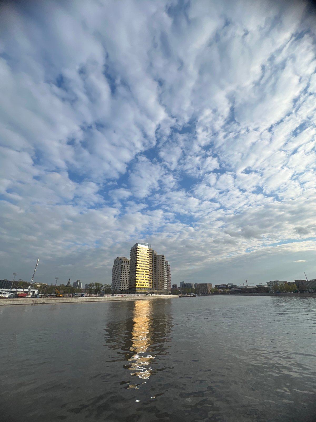 Woman takes riverside selfie in Moscow cityscape