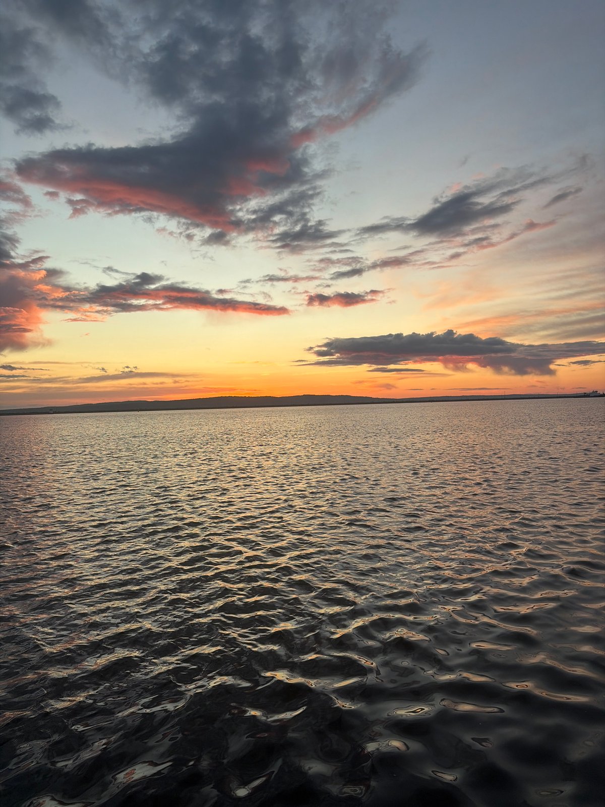 Dramatic sunset with pink-orange clouds witnessed over urban waterfront