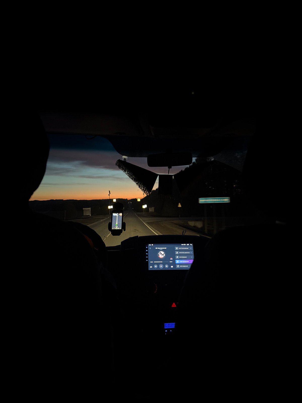 Driver captures colorful twilight sky during nighttime journey in Russia