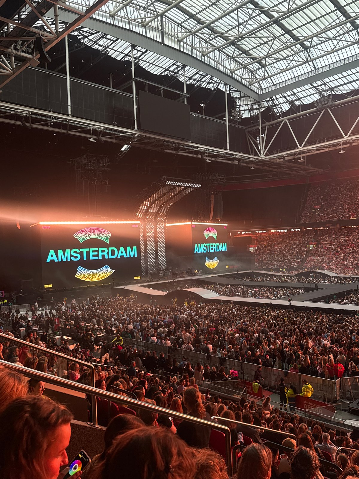 Crowd gathers at Amsterdam stadium event with branded displays