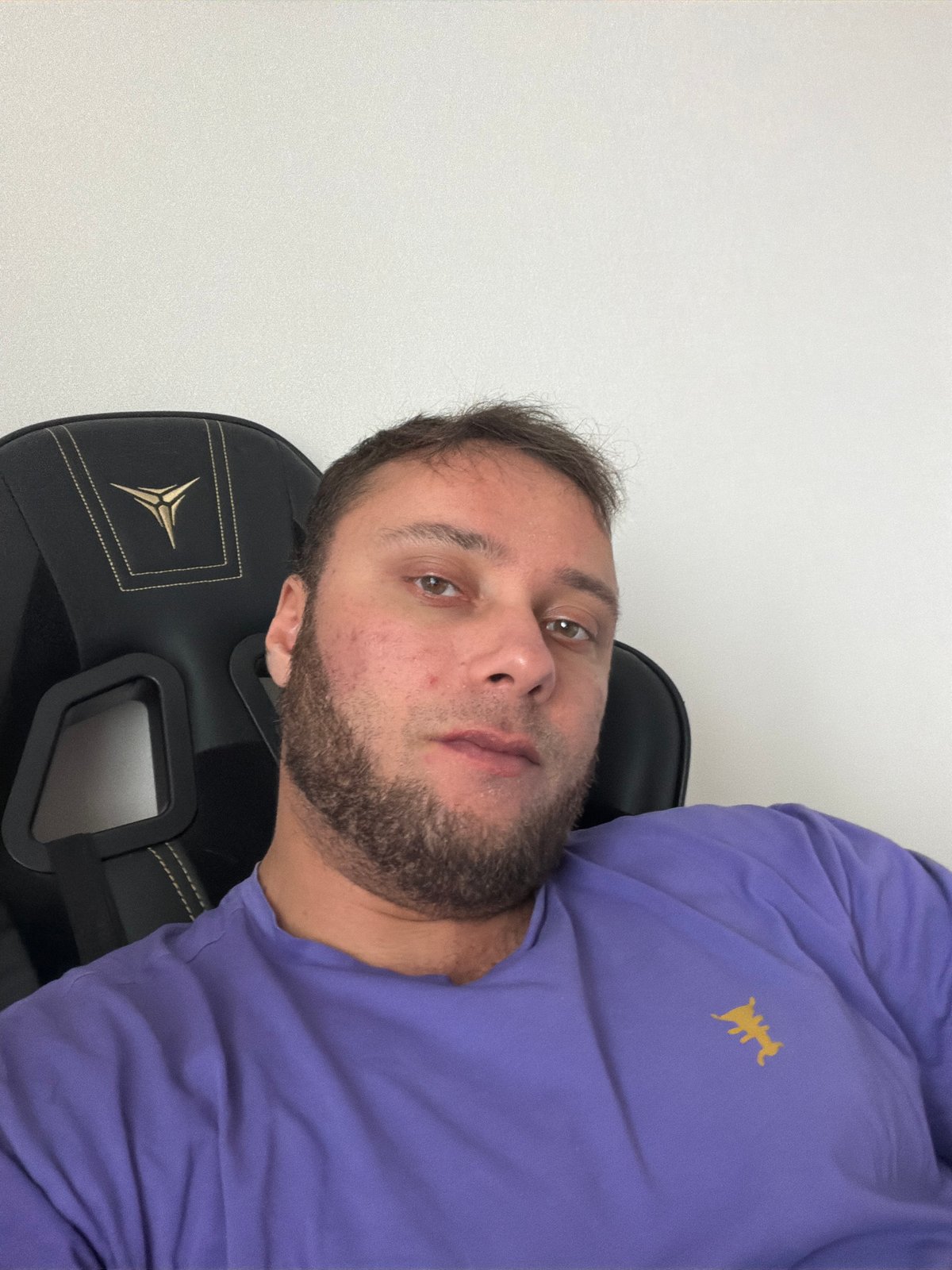Man in purple shirt observed in gaming chair, Chaikovsky