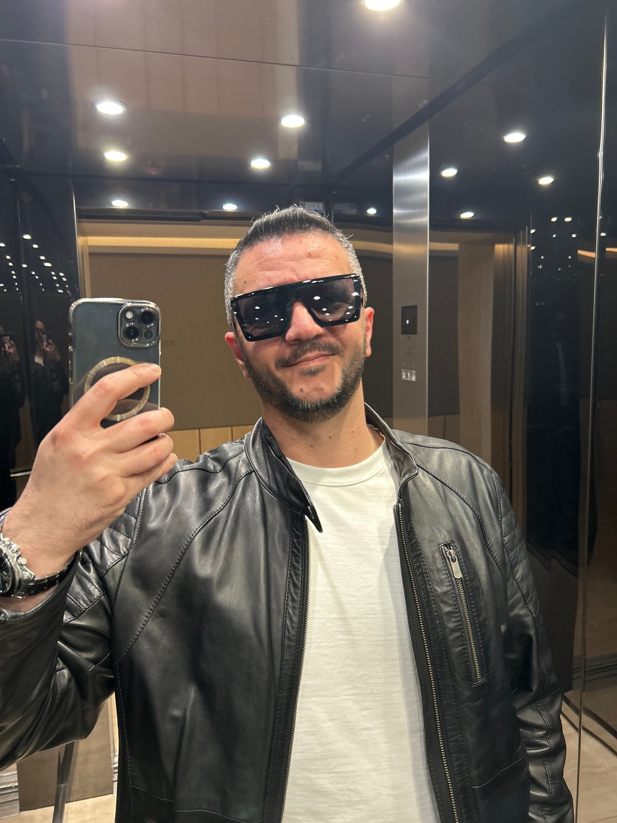 Man takes selfie in Berlin elevator wearing leather jacket