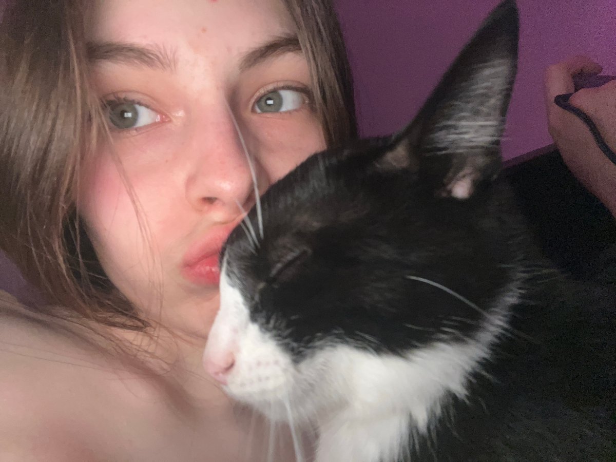 Person takes intimate selfies with black and white cat
