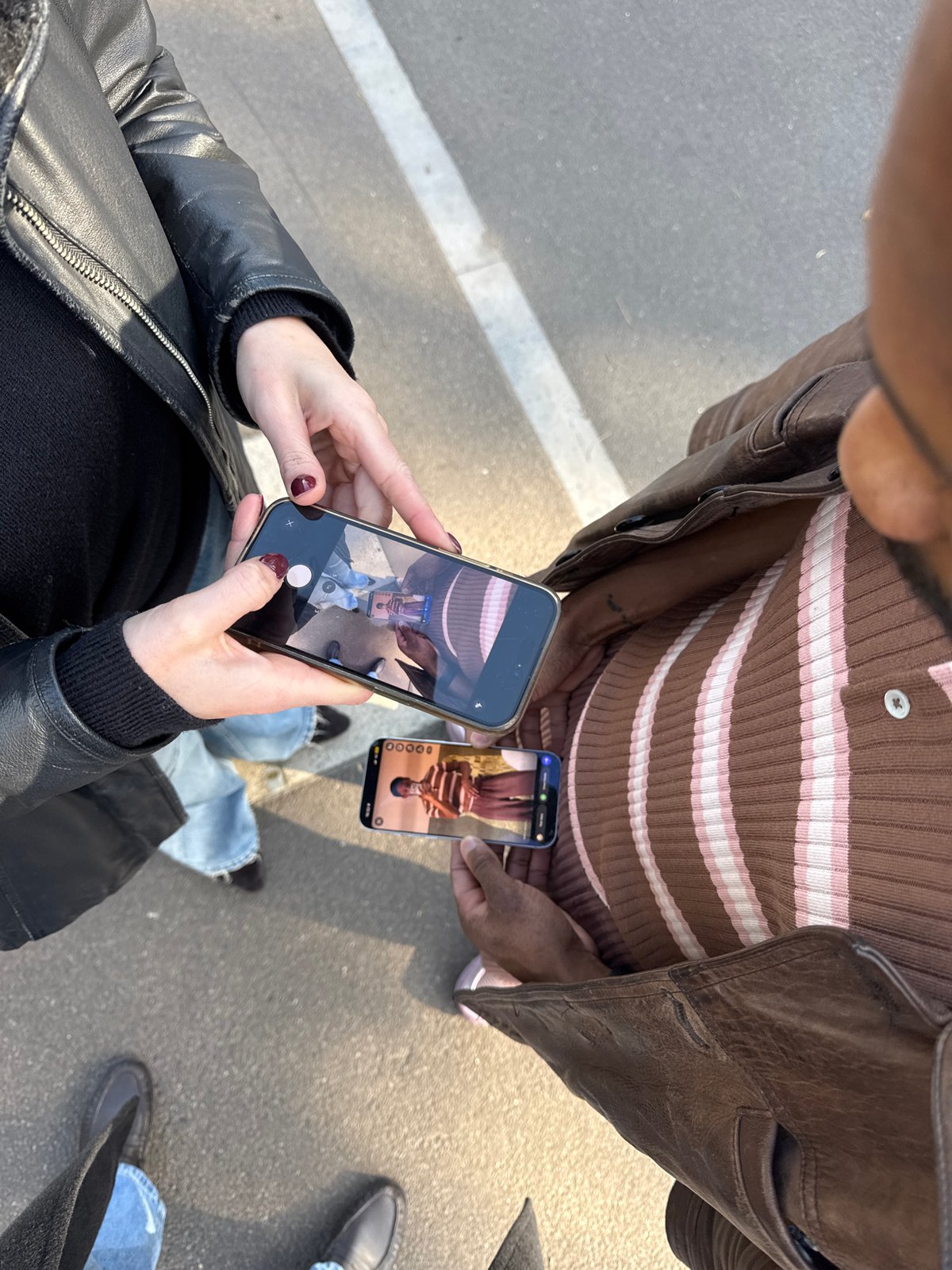 Couple photographing with smartphones captured in Folkestone street scene