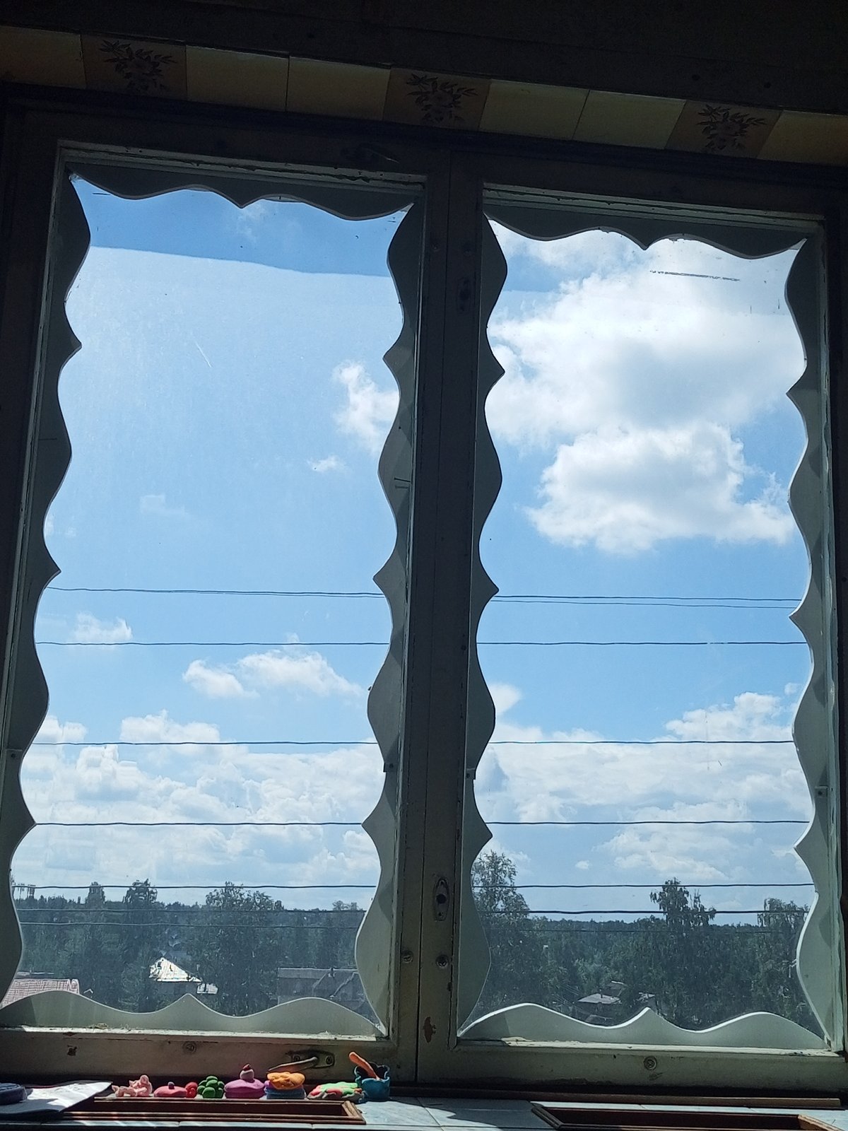 Blue sky over Vsevolozhsk, framed by windows and power lines