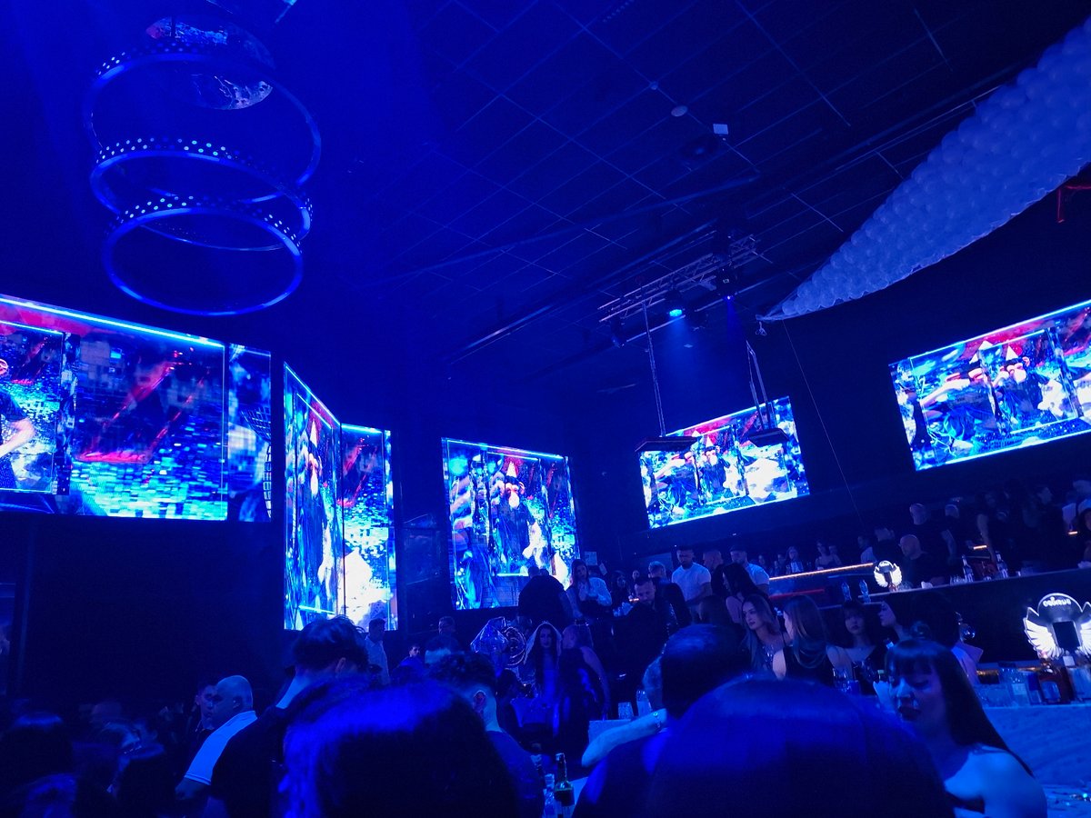 Blue-lit venue with hanging screens captured in Plovdiv