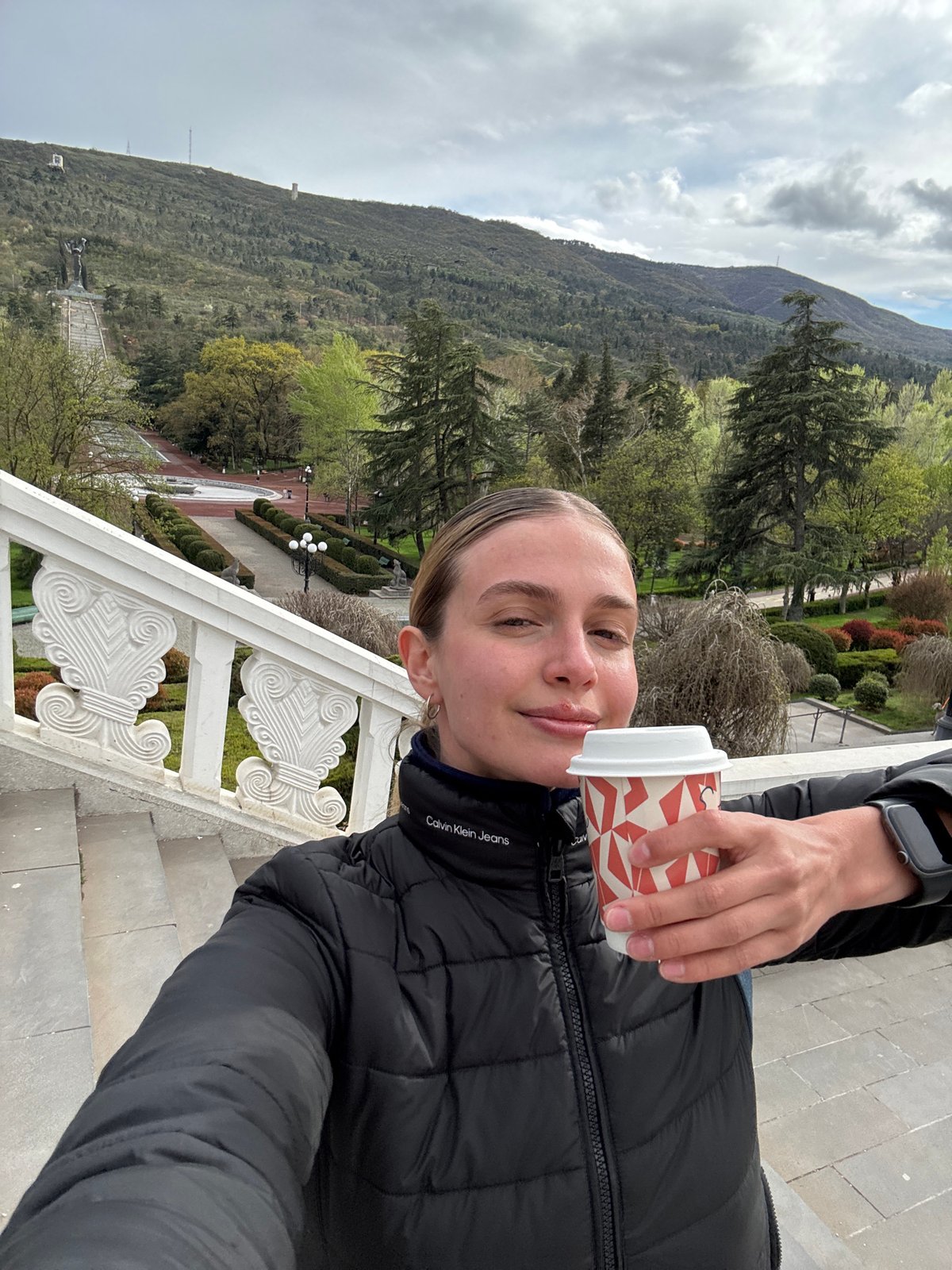 Woman takes selfie on ornate stairs in Tbilisi
